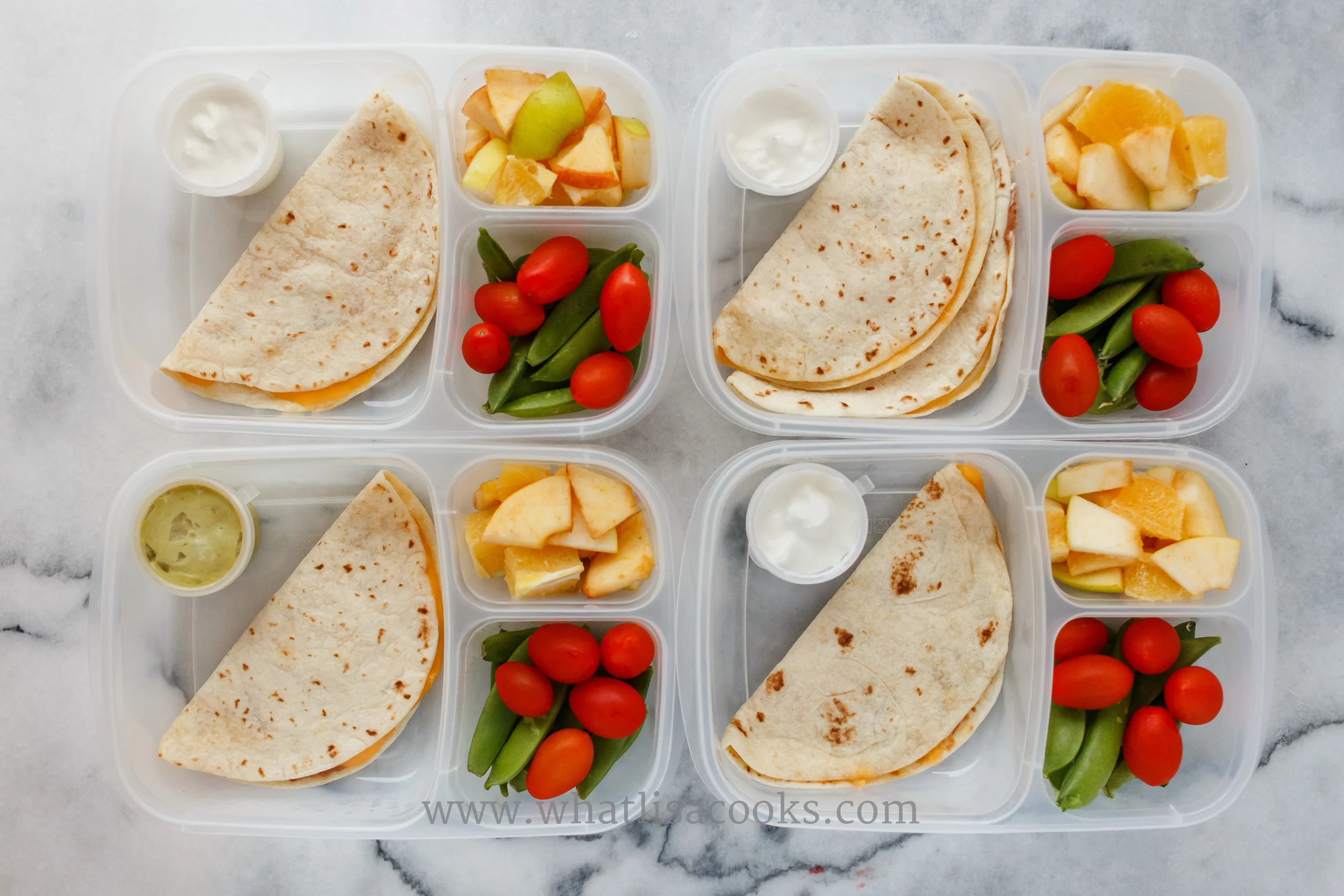 Quesadillas, two have beans and two have chicken. Three have sour cream for dipping and one has guacamole. Plus apple bites, sugar snap peas, and tomatoes. 