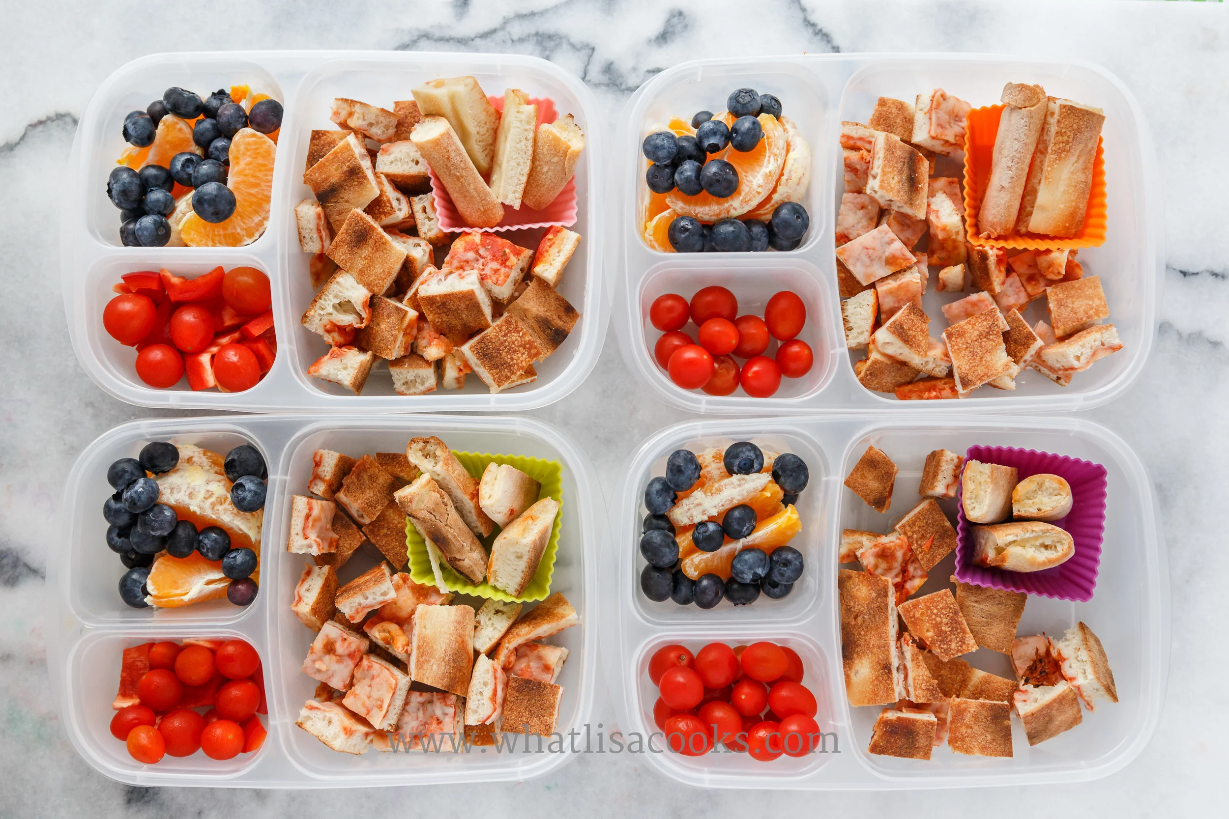 Leftover pizza cut in bites for easier and faster eating, with oranges, blueberries, and tomatoes. Packed in Easy Lunchboxes . 