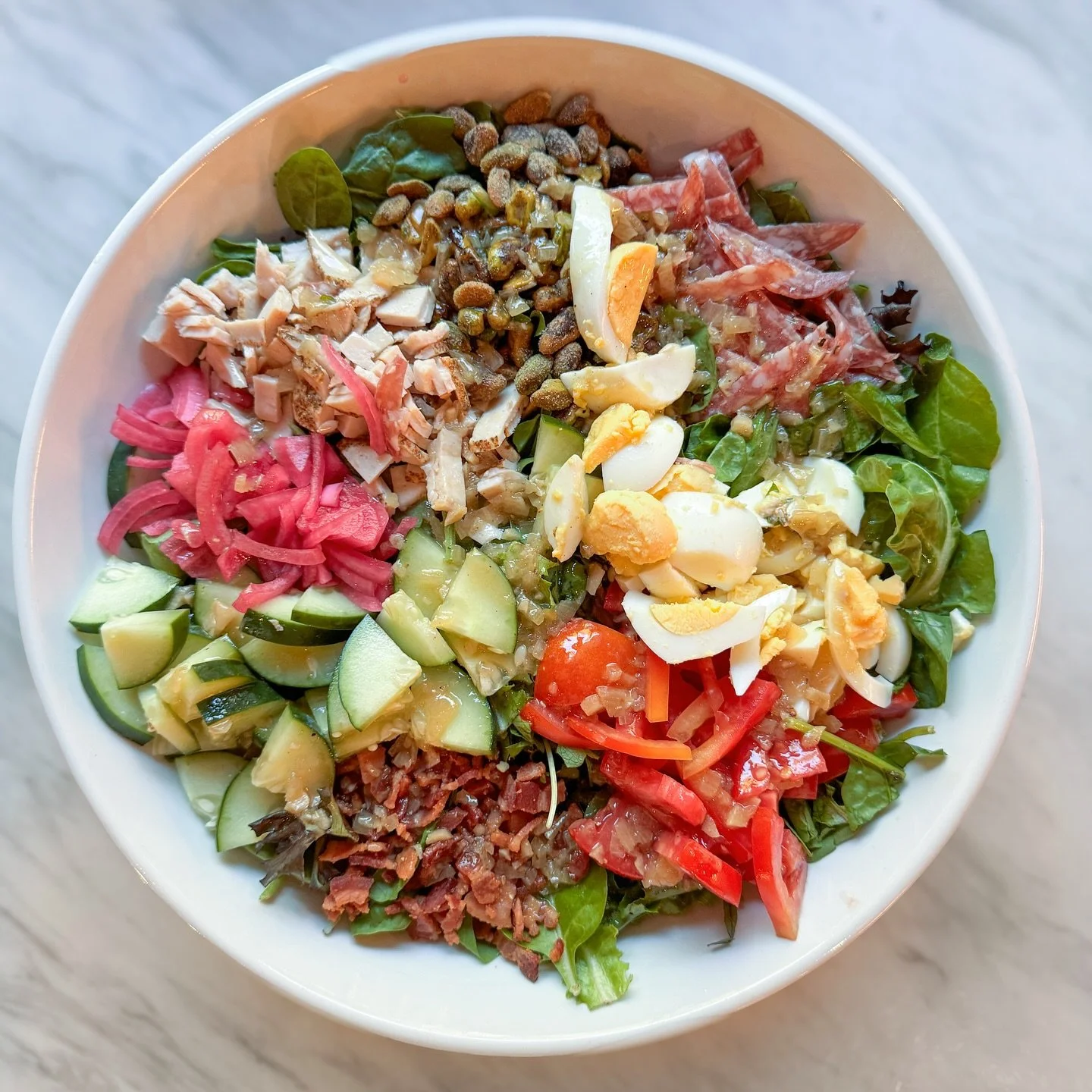 A big salad to go with Friday pizza. This one has bacon, turkey, boiled egg, salami, tomatoes, cucumber, pickled red onion, pistachios, and my lemon vinaigrette, on spring mix.