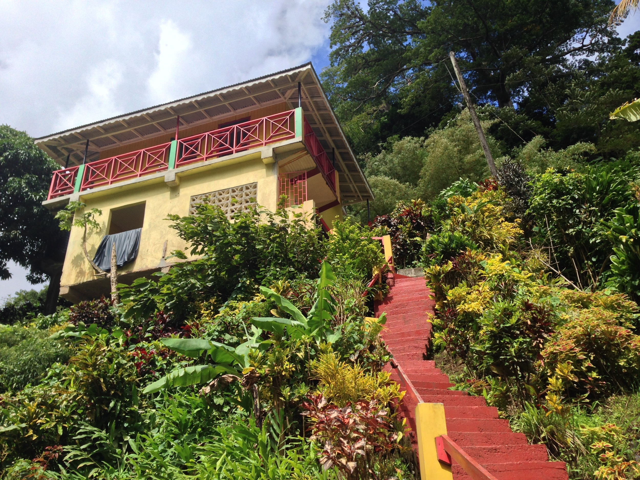 A mountain home near a waterfall in Grenada, painted in the national colors.
