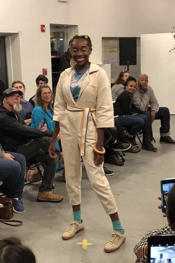 Mia wears an indigo shibori lawn tee and belt embellished with vintage trim with a jumpsuit by Hackwith care of Practice Space. Her earrings are by Peston and the bangle is by Non Issue Studio