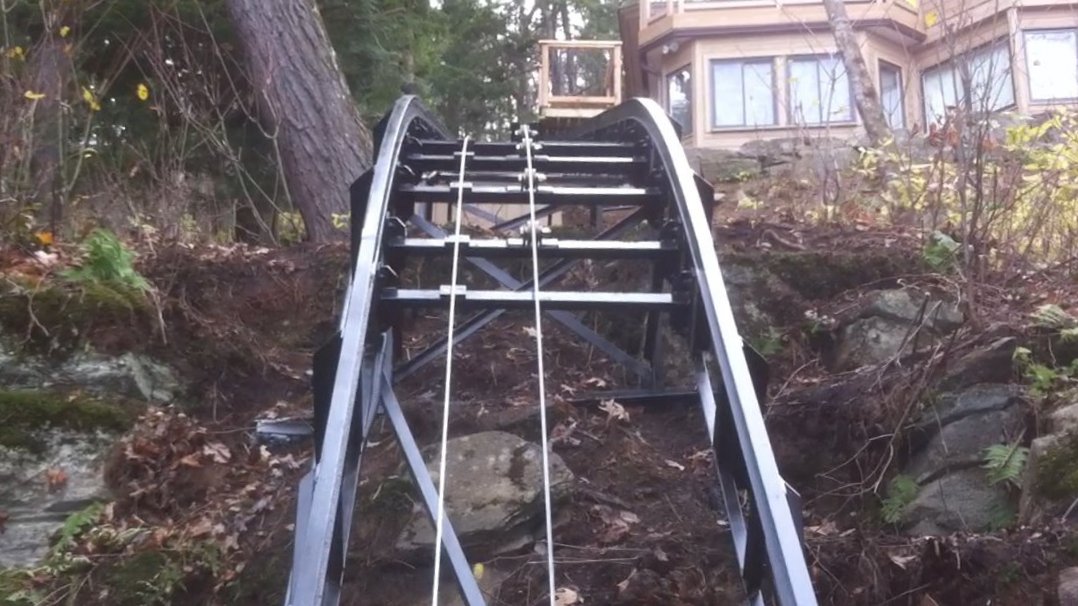 Heavy duty "V" rollers are used to curve the suspension cable smoothly over the curve in the track. The cable on the left side turns the governor that trips the overspeed brakes if the car goes faster than 0.5 m/sec or ~100 fps.