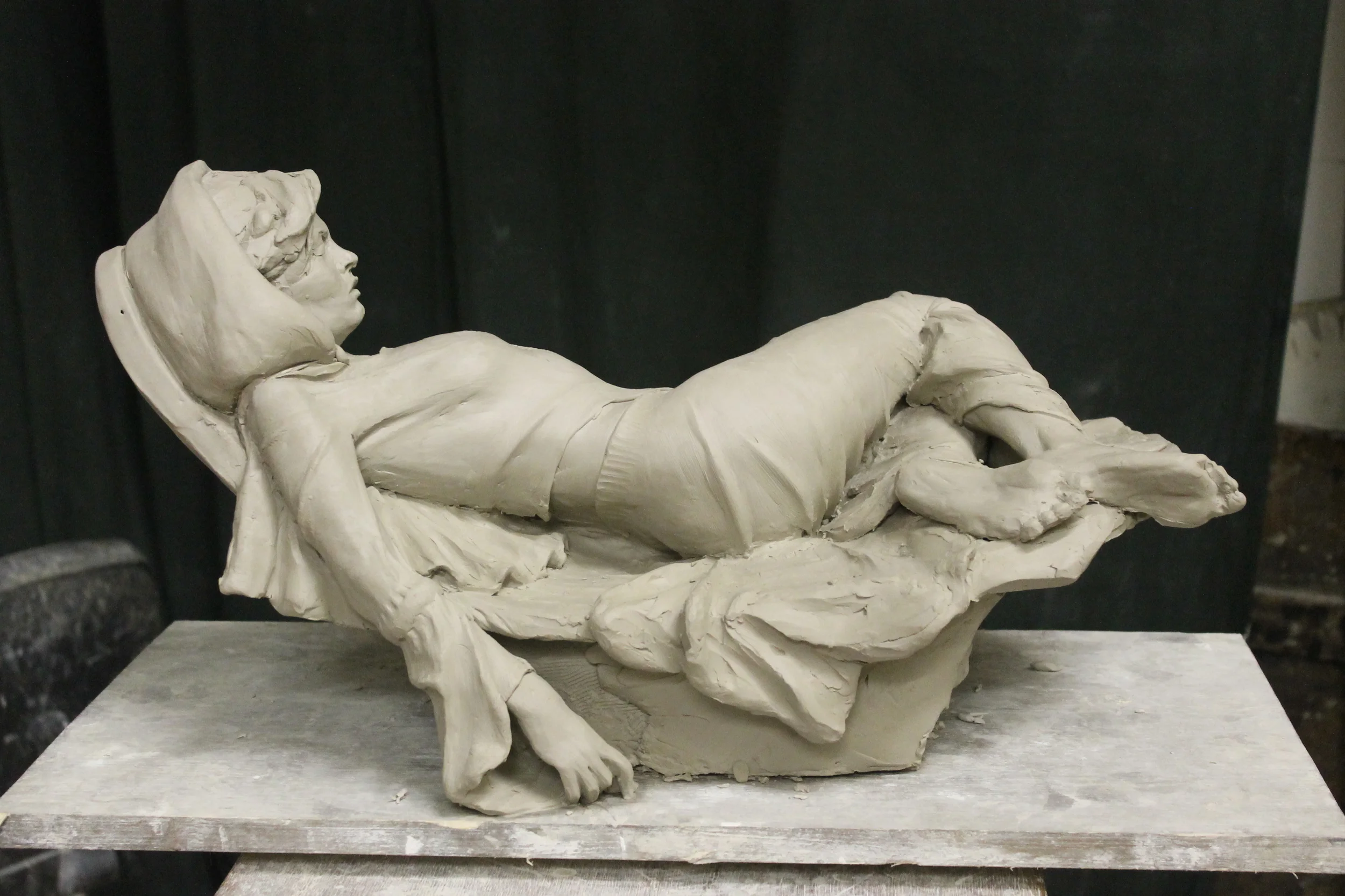 clay cast from press mold, with drapery added and arm position altered from original position.
