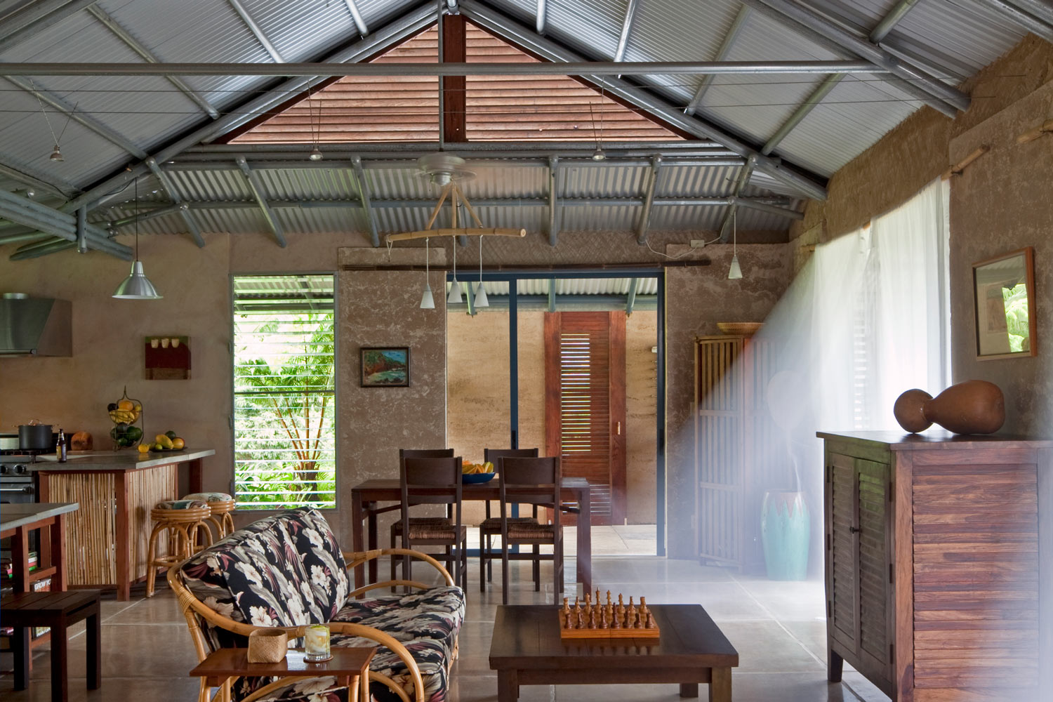  The key to comfort in the tropics is ventilation - lots of it. We used supporting earth walls as sparingly as possible. Big panels of sliding glass open to mimic the original concept of a Hawaiian hale. Open gable ends and cupolas keep the air flowi