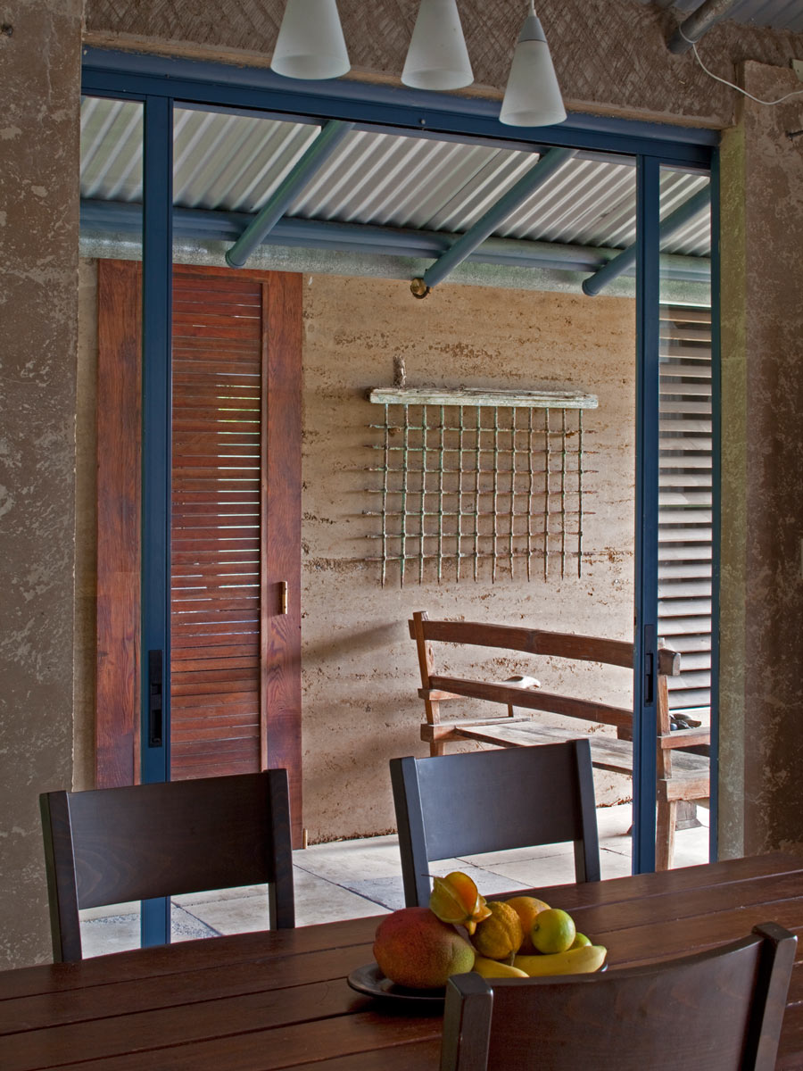  View through the sliding dining room wall glass panels into the breezeway. Tradewinds pick up speed as the funnel through the breezeway, pulling heat from the living spaces.   Image © Art Gray  