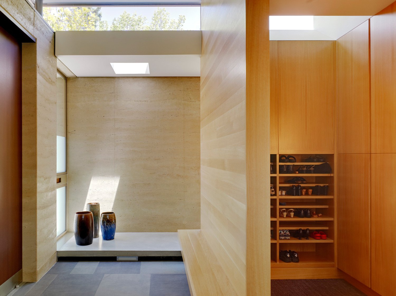 For the interiors, the architect chose wood paneling that mimic the color and the layering of the rammed earth walls. Image © Joe Fletcher