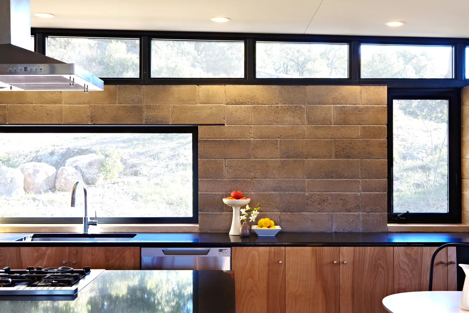 Bronze anodized window frames, black Cesarstone contertops, natural birch cabinets and Watershed Blocks. Lighted from above as they are here, the color variations in each individual block reveal the minerality of their composition. Find out more at the Watershed Materials website.