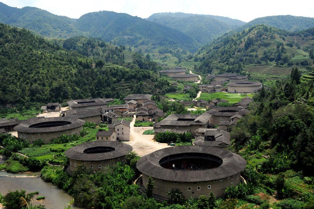 The thick earth walls of China Fujian Tulou, here shown in the Hekeng cluster, have been providing their inhabitants with cool daytime temperatures and warm nighttime temperatures for hundreds of years. Image credit Fon Zhou , used with permission of Creative Commons Attribution-NonCommercial 2.0 license. 