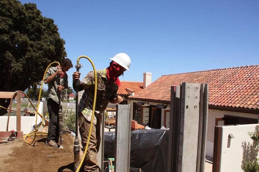 Rammers have reached the top of the rammed earth wall that surrounds the now buried eucalyptus branches.