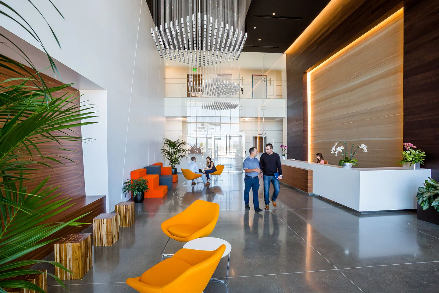 The new rammed earth, slimmed down and ready for the show, complements the palette of crisp, modern finishes in the lobby of the six-story Stadium TechCenter in Santa Clara, California. Interior design by SmithGroupJJR .