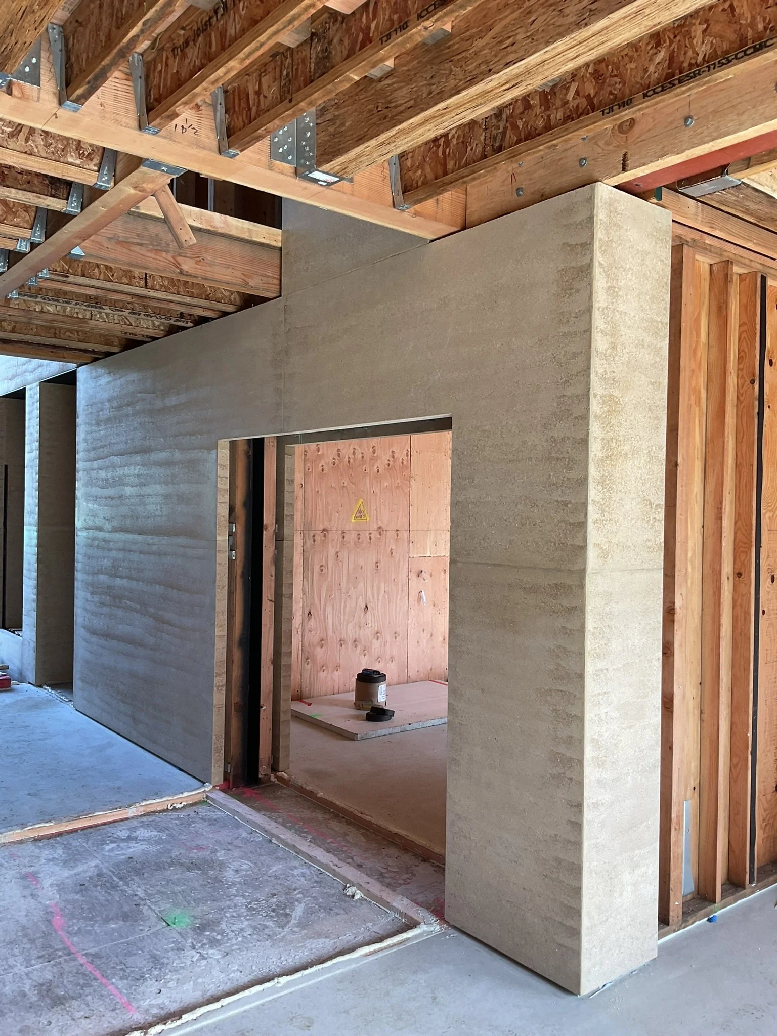  This home spanned three stories, with rammed earth panels being placed throughout the home from the basement to the top floor master bedroom with a panel being used as a headboard. 