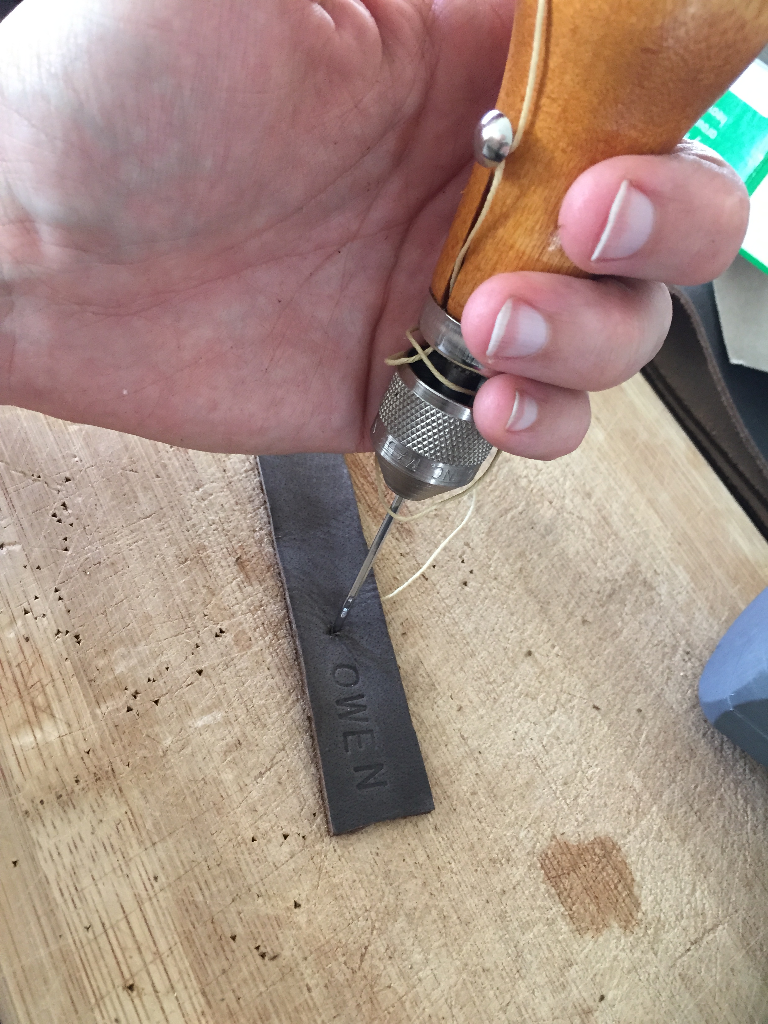 Once finished stamping the letters, punch out a hole for the rivets.
