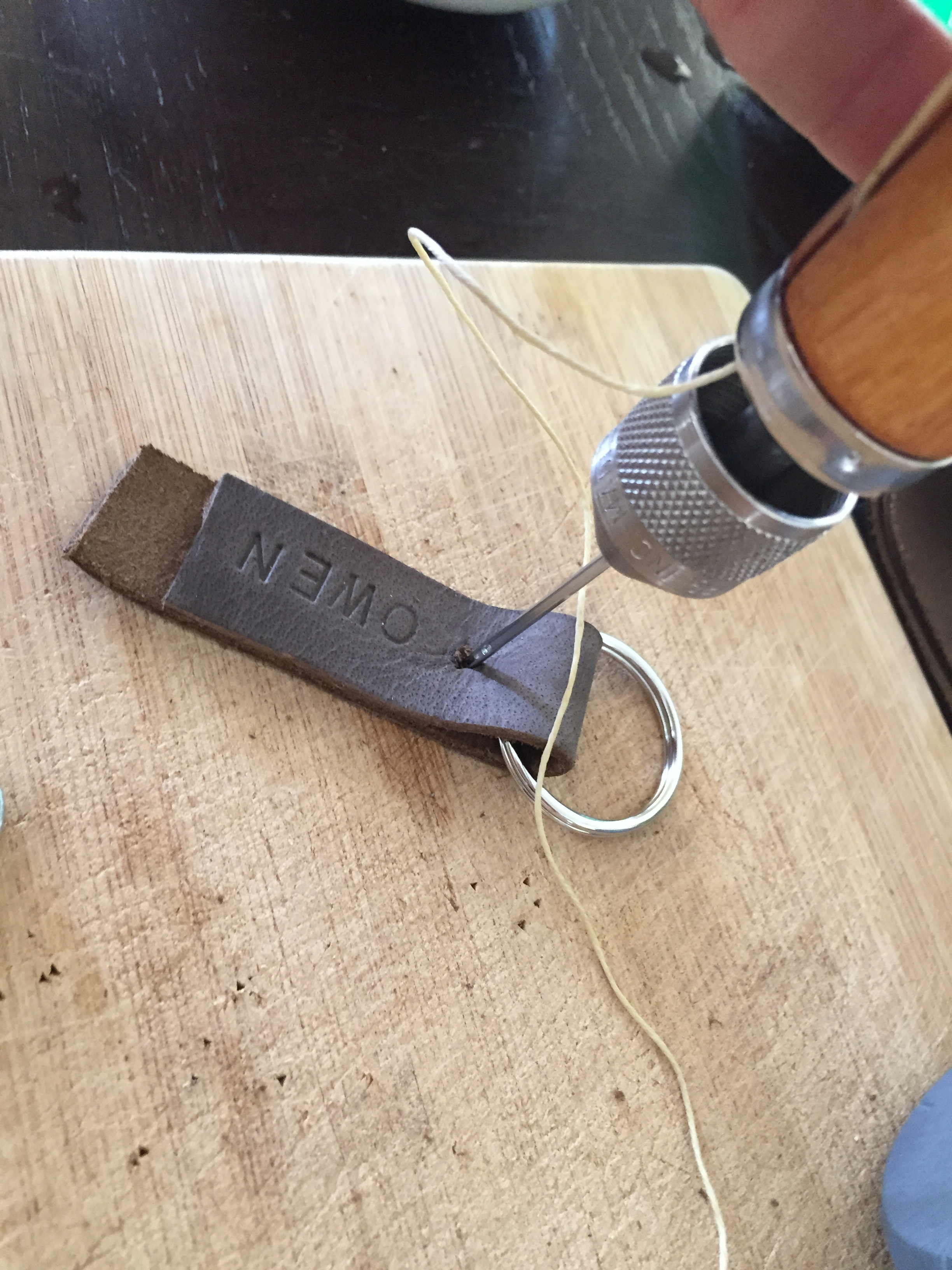  Fold the piece around the keyring to figure out where to punch the second hole before installing the rivet. 