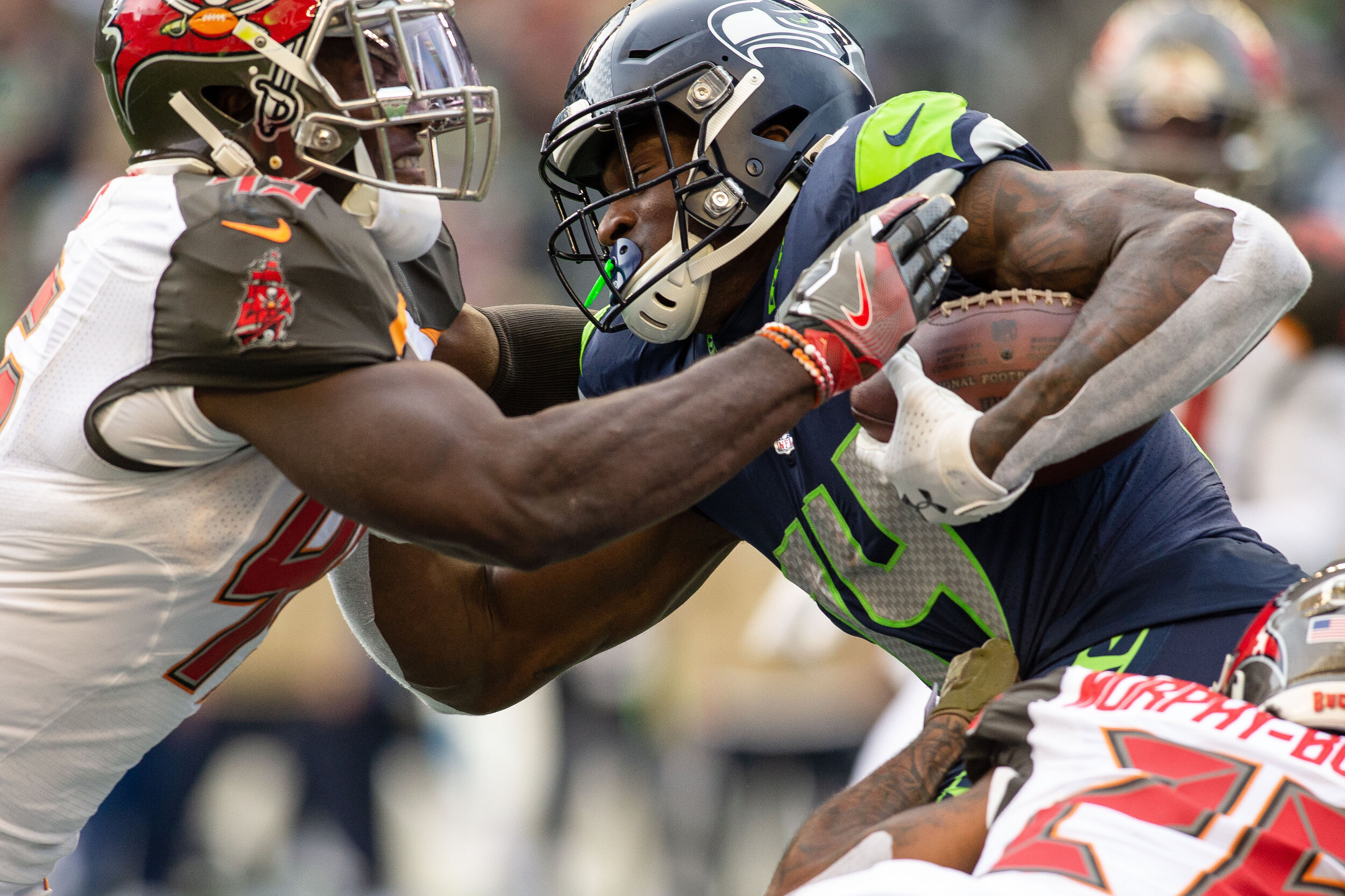  Seattle Seahawks wide receiver D.K. Metcalf (14) runs with the ball after contact with Tampa Bay Buccaneers defensive back Sean Murphy-Bunting (26) and linebacker Devin White (45) during the third quarter of an NFL football game, Sunday, Nov. 3, 201
