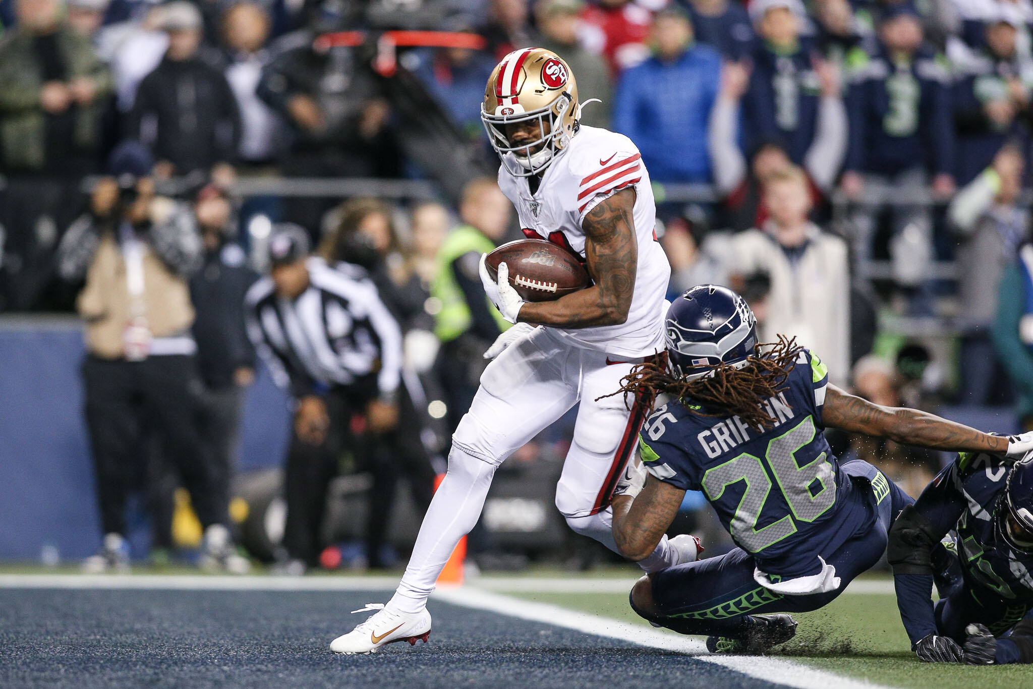  San Francisco 49ers running back Raheem Mostert (31) runs past Seattle Seahawks defensive back Lano Hill (42) and outside linebacker Shaquem Griffin (49) to score a touchdown during the fourth quarter of an NFL football game, Sunday, December 29, 20