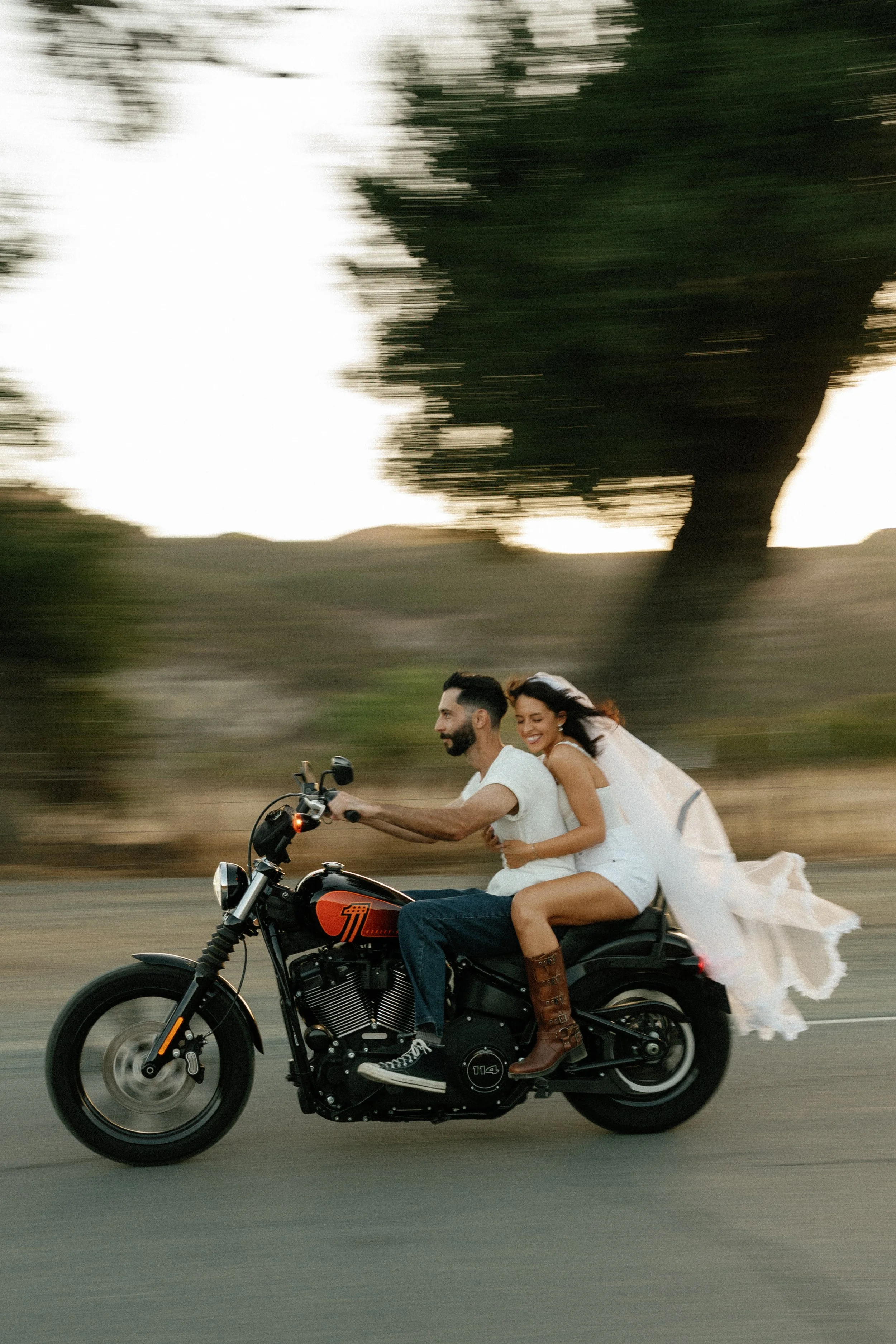 couple drives away on motorcyle  in documentary style engagement photos