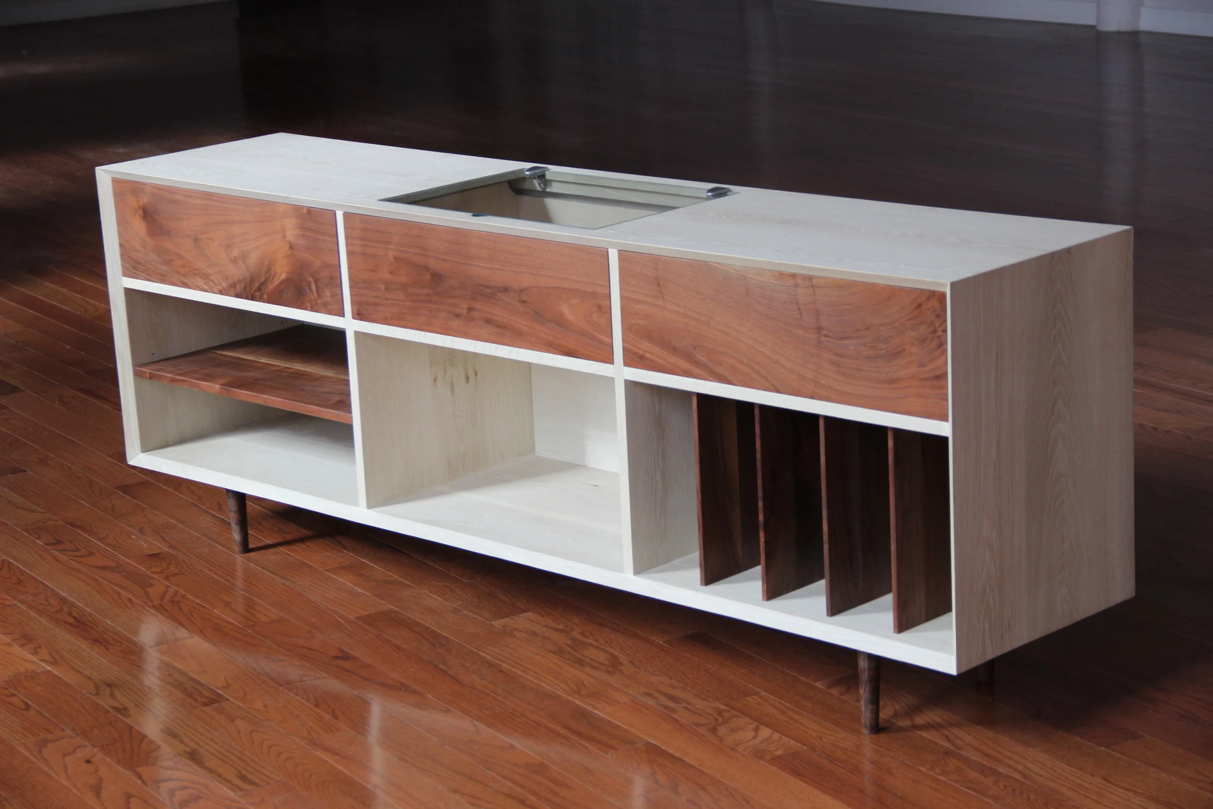  Bleached white oak and walnut media console. Glass top in the center lifts to access record player. 