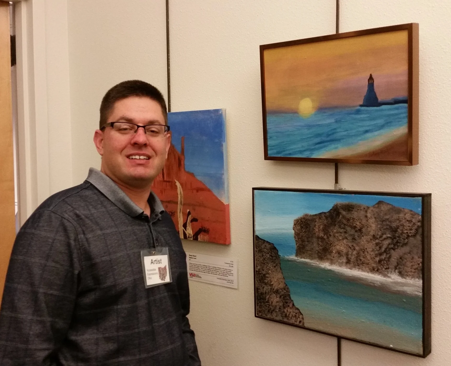 Tony with his beautiful oil painting "Elbert Beach" (top right) Nathan Lucal's painting "Sunny Dessert" is behind Tony