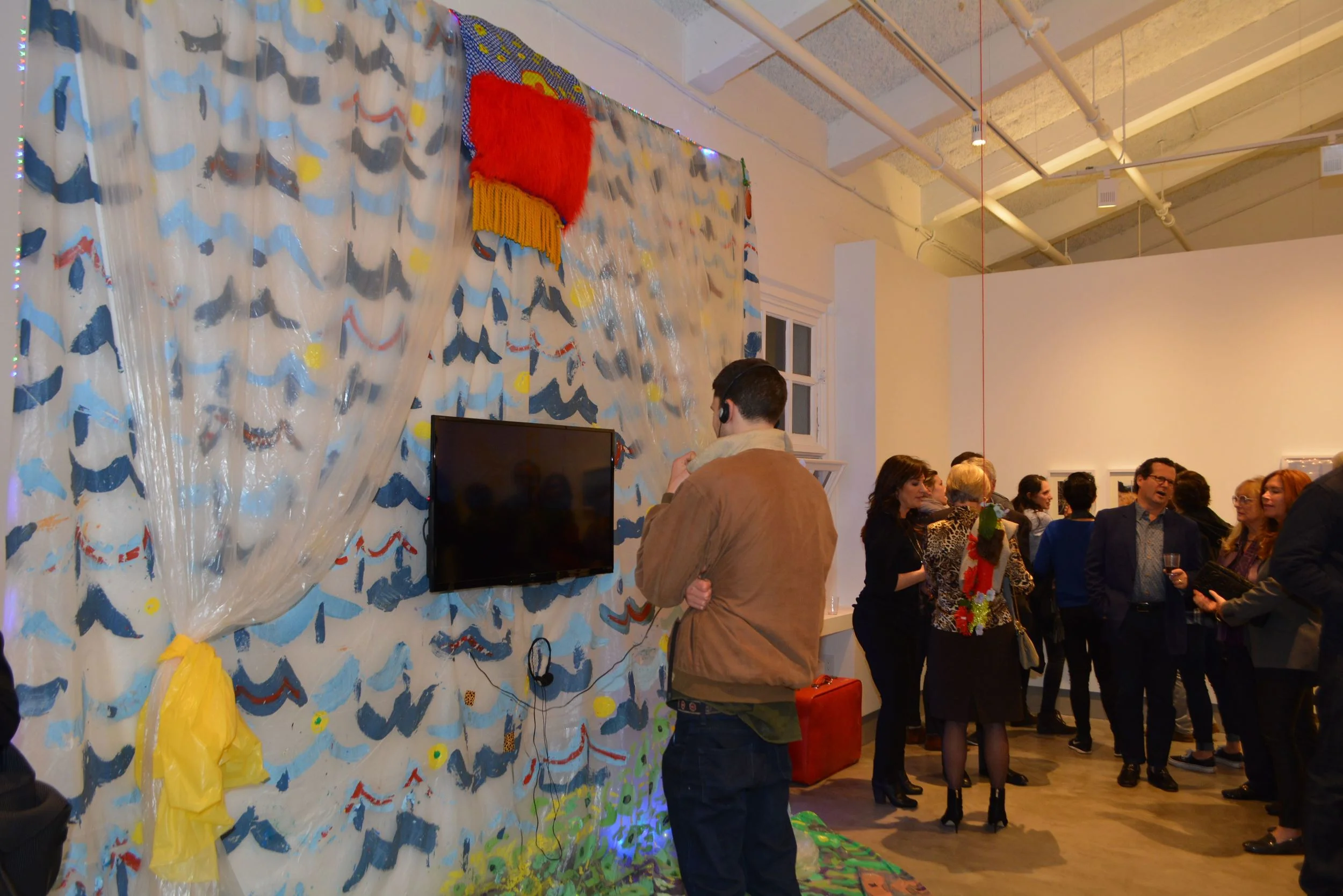 A guest takes in Jose Figueroa's video installation Untitled (The Perfect Way) as the gallery becomes crowded.