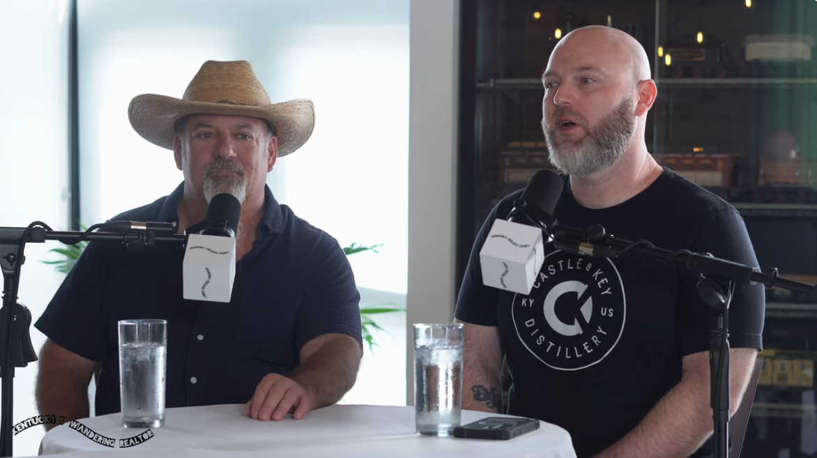 Jason Brauner and Chef Jereme McFarland of Bourbons Bistro seated at a table with microphones during their interview on Kentucky's Wandering Realtor podcast.