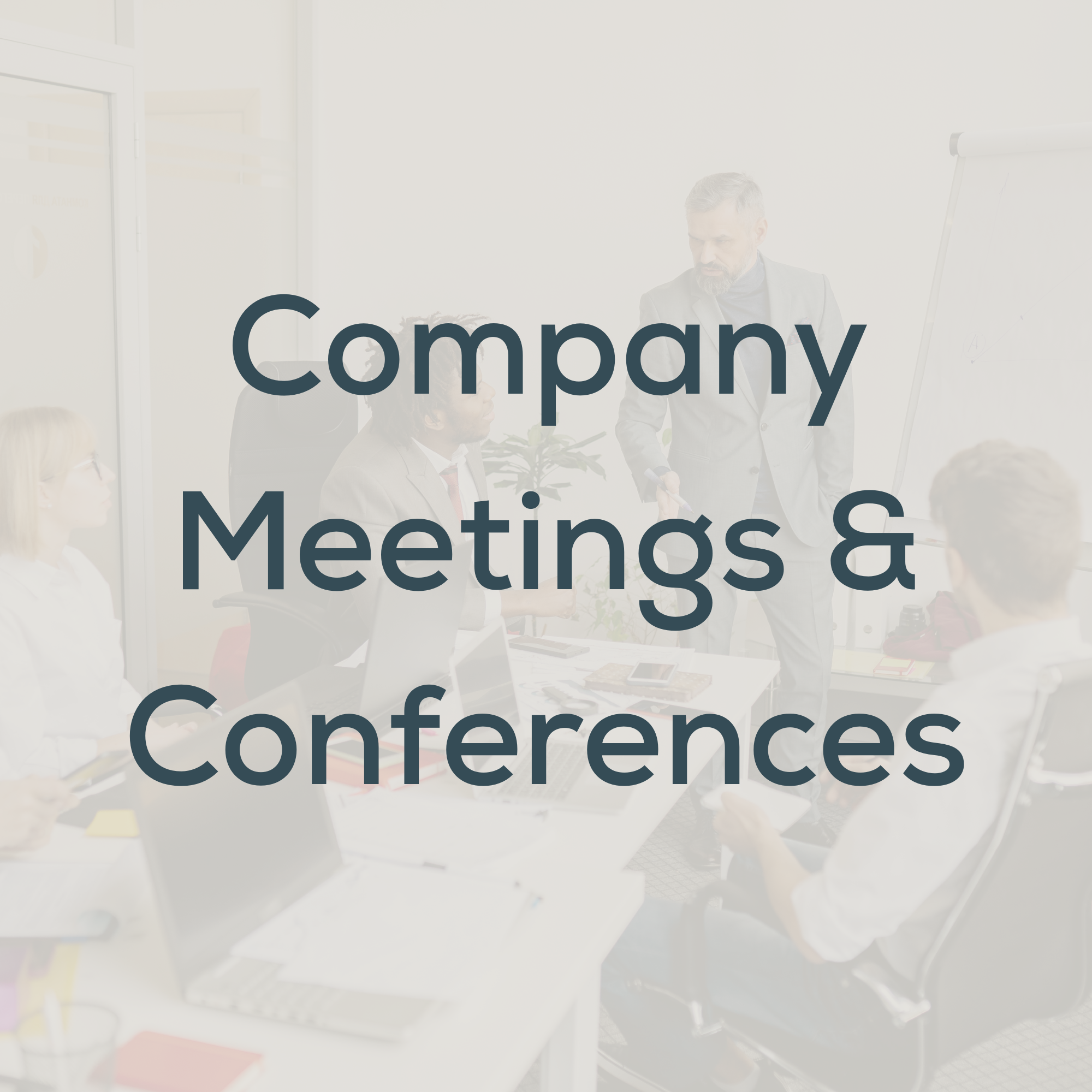 Business team in a meeting room, with a man standing and speaking to seated colleagues, in a professional office setting.