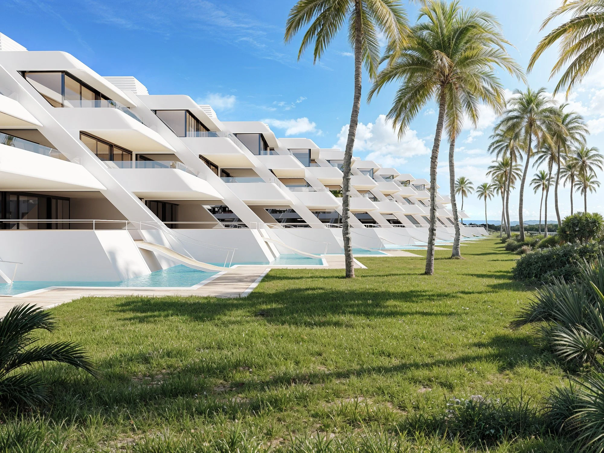 Modern beachfront resort with white geometric architecture, palm trees, green lawn, and clear blue sky.