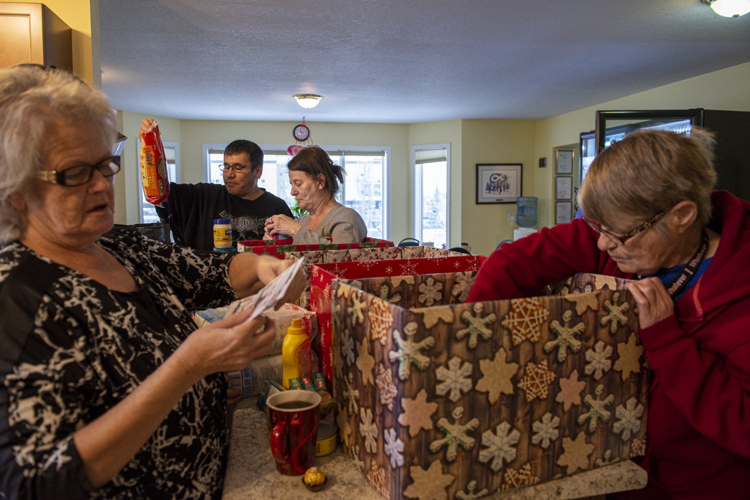  Residents and staff at the Elder’s Caring Shelter unpack boxes full of food donations in preparation for the holiday season.   Résidents et employés au Elder’s Caring Shelter déballent des boites de dons de nourritures en préparation de Noel. 