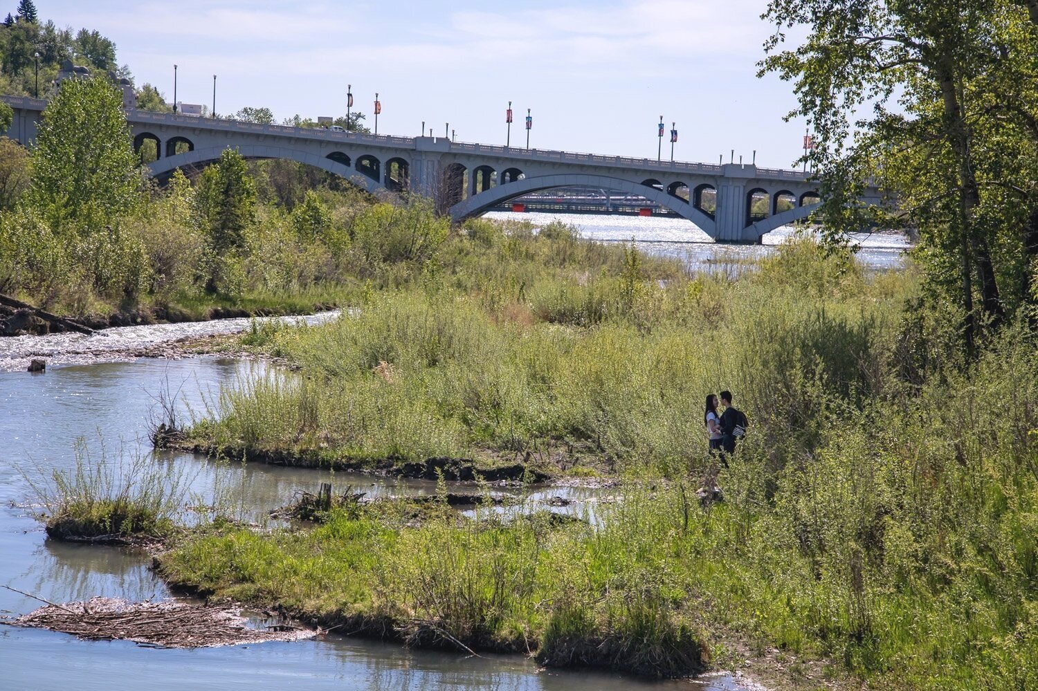  Teenagers embrace on the shore of the Bow River. As a riverfront community steps away from downtown, Chinatown is a prime real-estate location highly sought after by condo developers. 