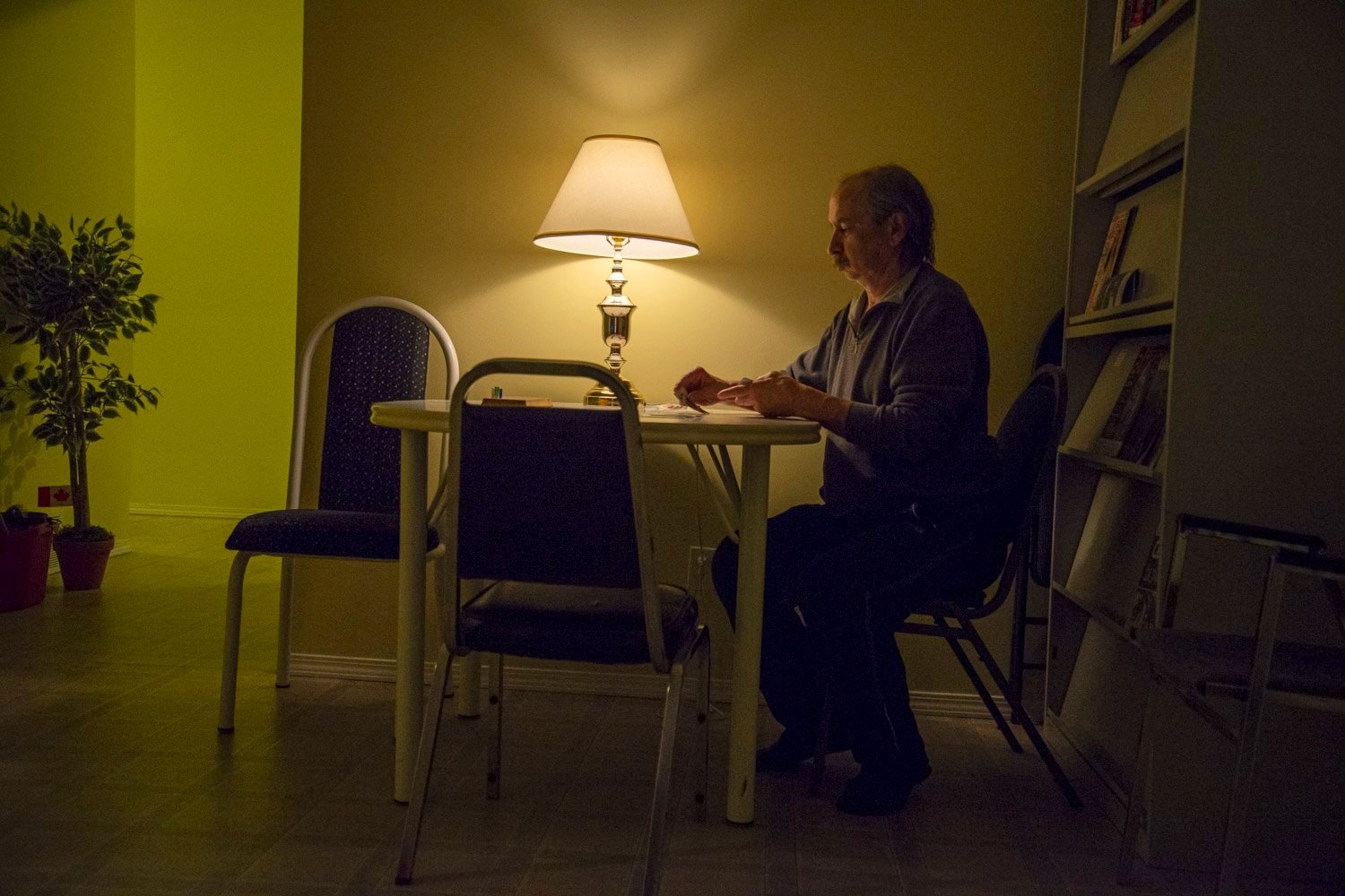  A resident plays card at the Elder’s Caring Shelter in Grande Prairie.  “I like to think of where I live as a sanctuary. I am very private so I sometimes find it hard to share my living space with others. On the other hand, there is a lot of people 