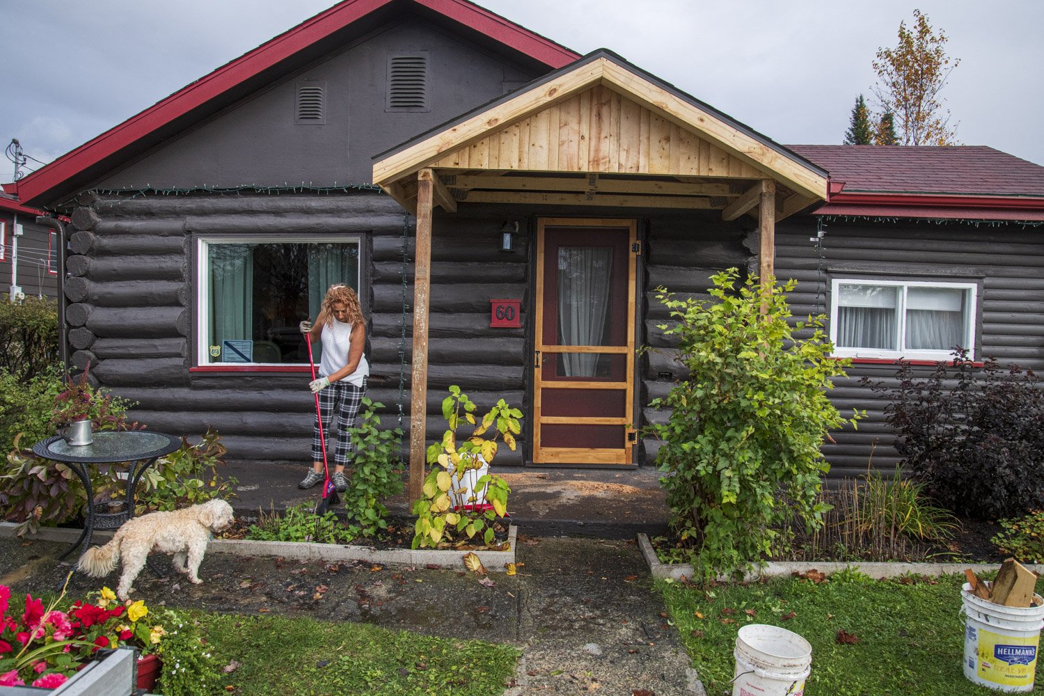  A resident sweeps her front porch after the village carpenter build an addition to her house. Residents can apply for financial supports to help alleviate the cost of home restoration as long as they follow government regulations and city bylaws. 