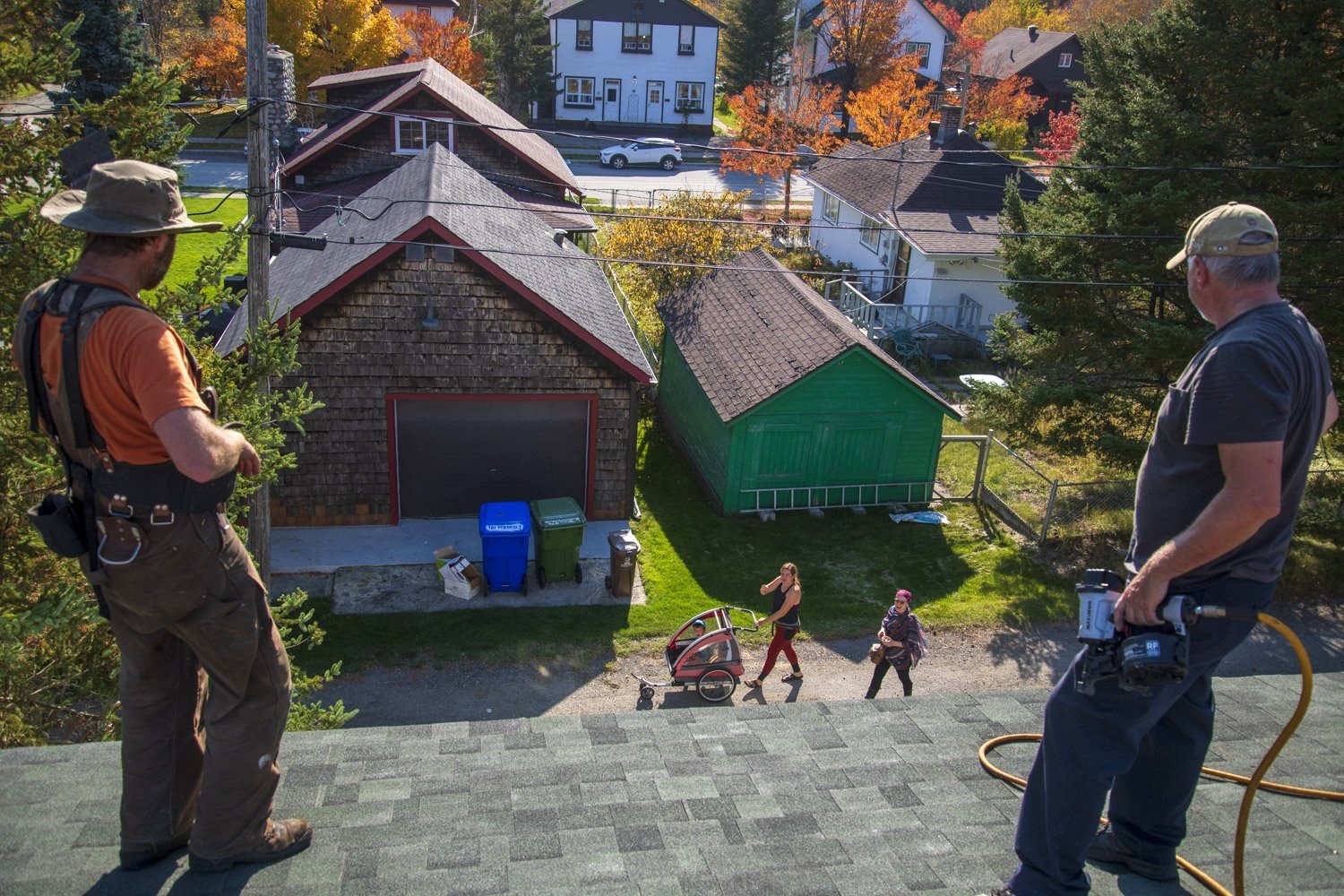  Sébastien Lafontaine (left) takes a moment to chat with his wife while roofing in the mining village of Bourlamaque. Owners can choose between five colours for exterior paint and two colours of shingles. Only wooden windows and doors can be replaced