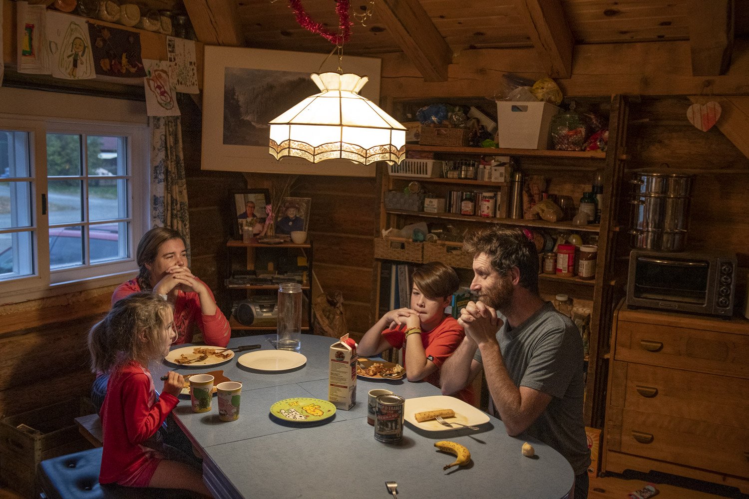  The Lafontaine family prays before breakfast at their home in the mining village of Bourlamaque. Sébastien (right), a carpenter, rebuild his house from the ground up while maintaining and preserving the heritage and cultural integrity of the origina