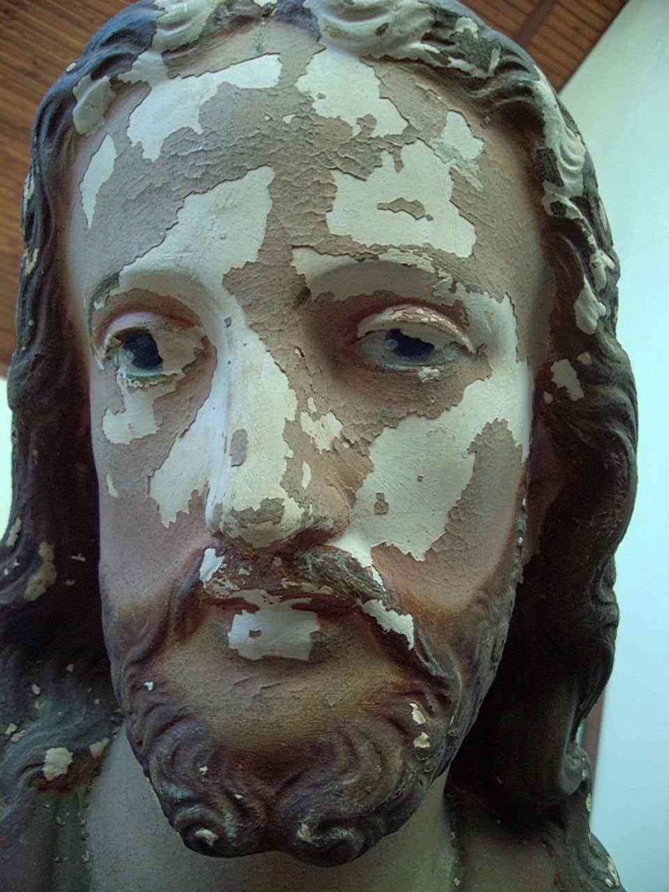 Detail: Damaged head / face of plaster statue “Sacred Heart of Jesus”