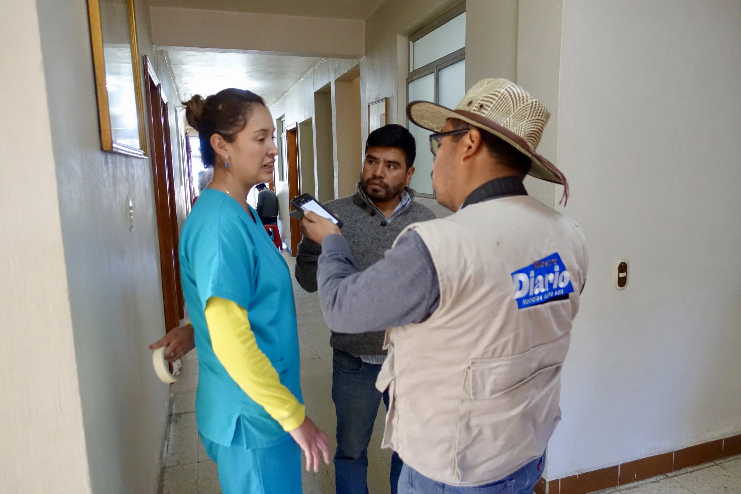 A reporter from Nuestro Diario interviewing Dr. Valeria about the clinic at ACAM
