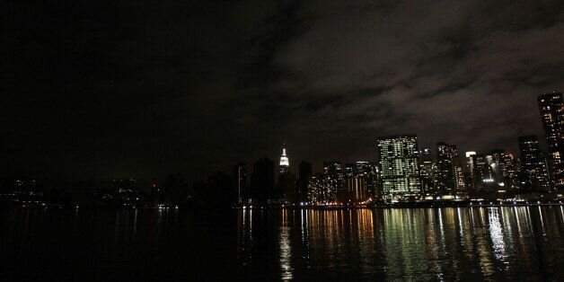 2012年10月30日，飓风桑迪过后的一天，曼哈顿下城漆黑的天际线。连接到电网的建筑物失去了电力，而连接到微电网的建筑物仍然有电力。图片来源:MEHDI TAAMALLAH/AFP/Getty I…