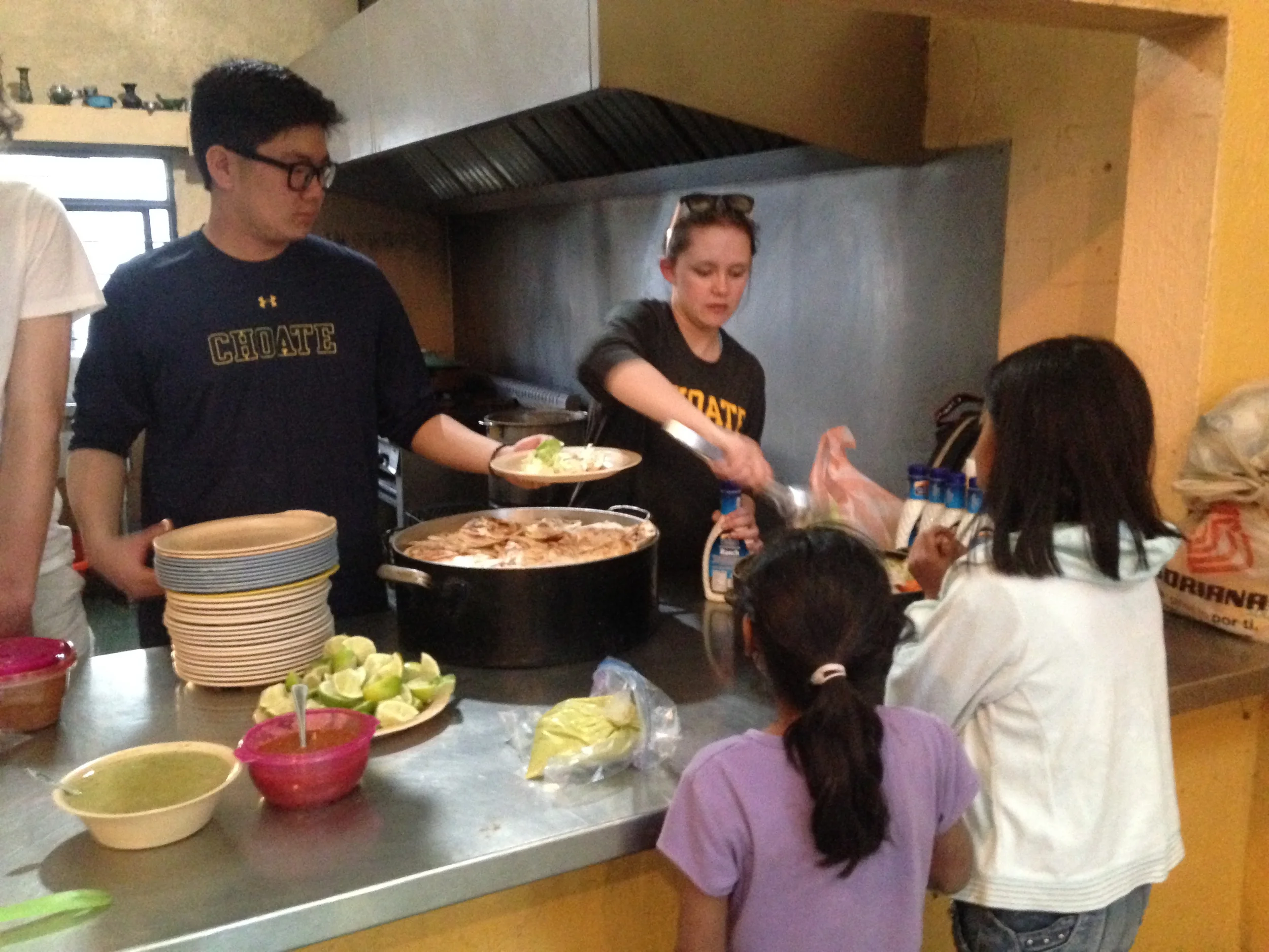 YJ (left) and Choate schoolmate Nicole serve the children for a Sunday night dinner at Casa Hogar!