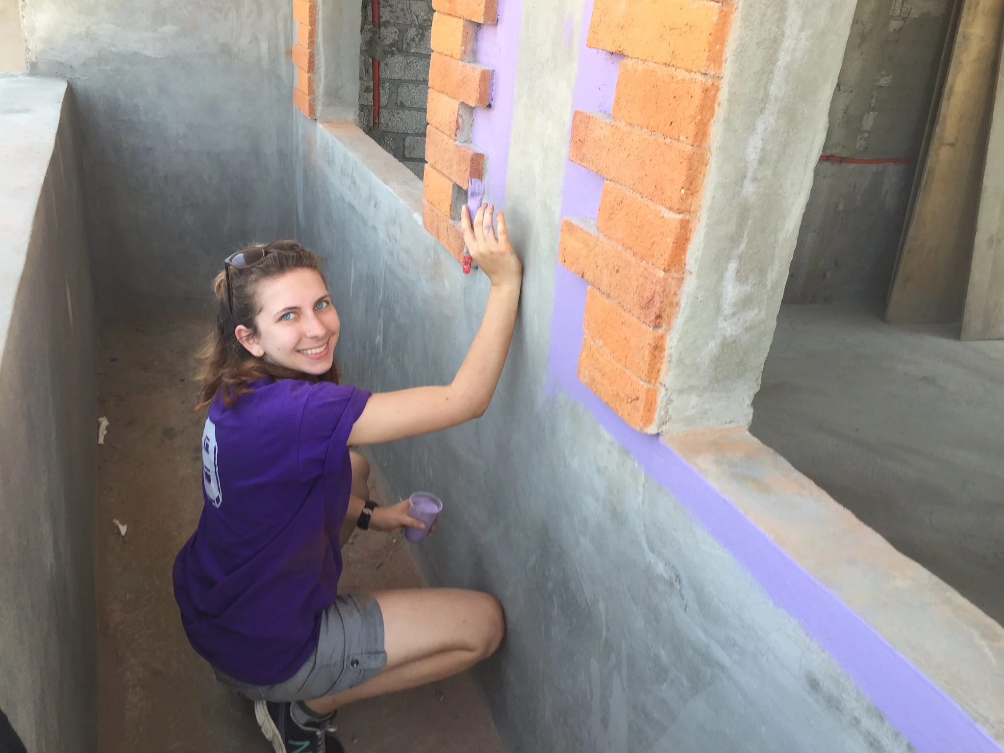 Danielle paints the exterior of a new laundry room at Casa Hogar Simply Smiles.