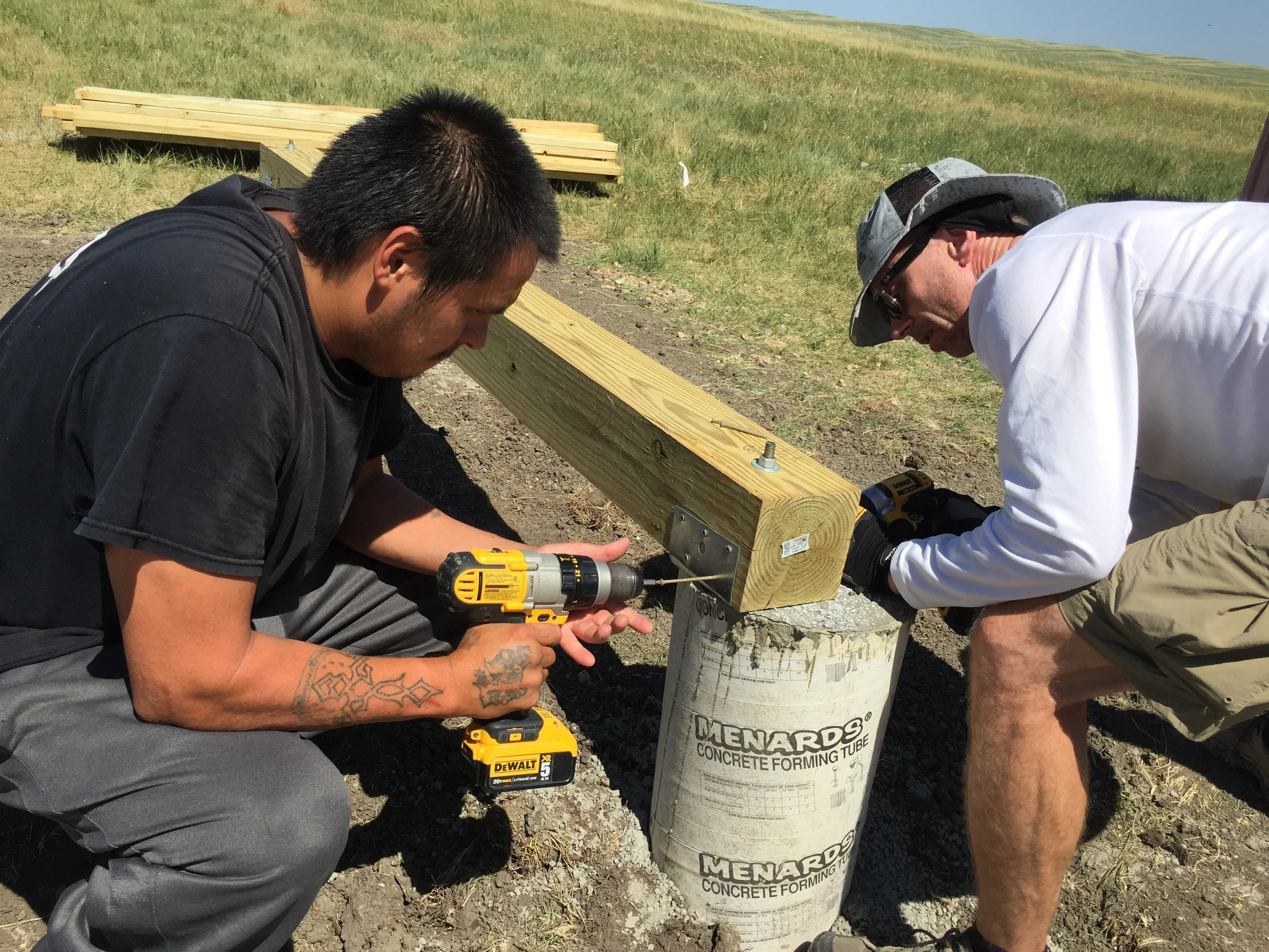 Dennis, right, works with Jeremy from La Plant to build the foundation of a wood pellet shed at the new homes.