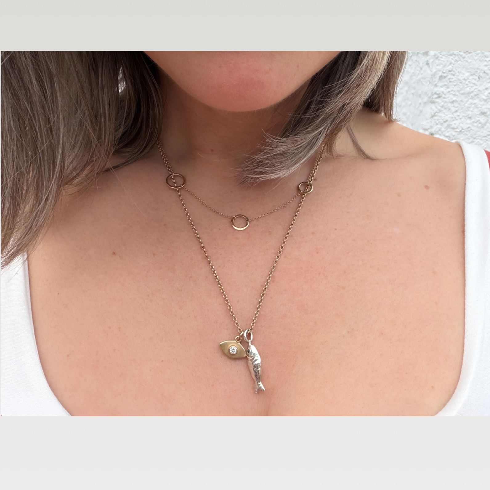 lucky silver fish pendant with teal sapphire eye and 14k diamond evil eye pendant