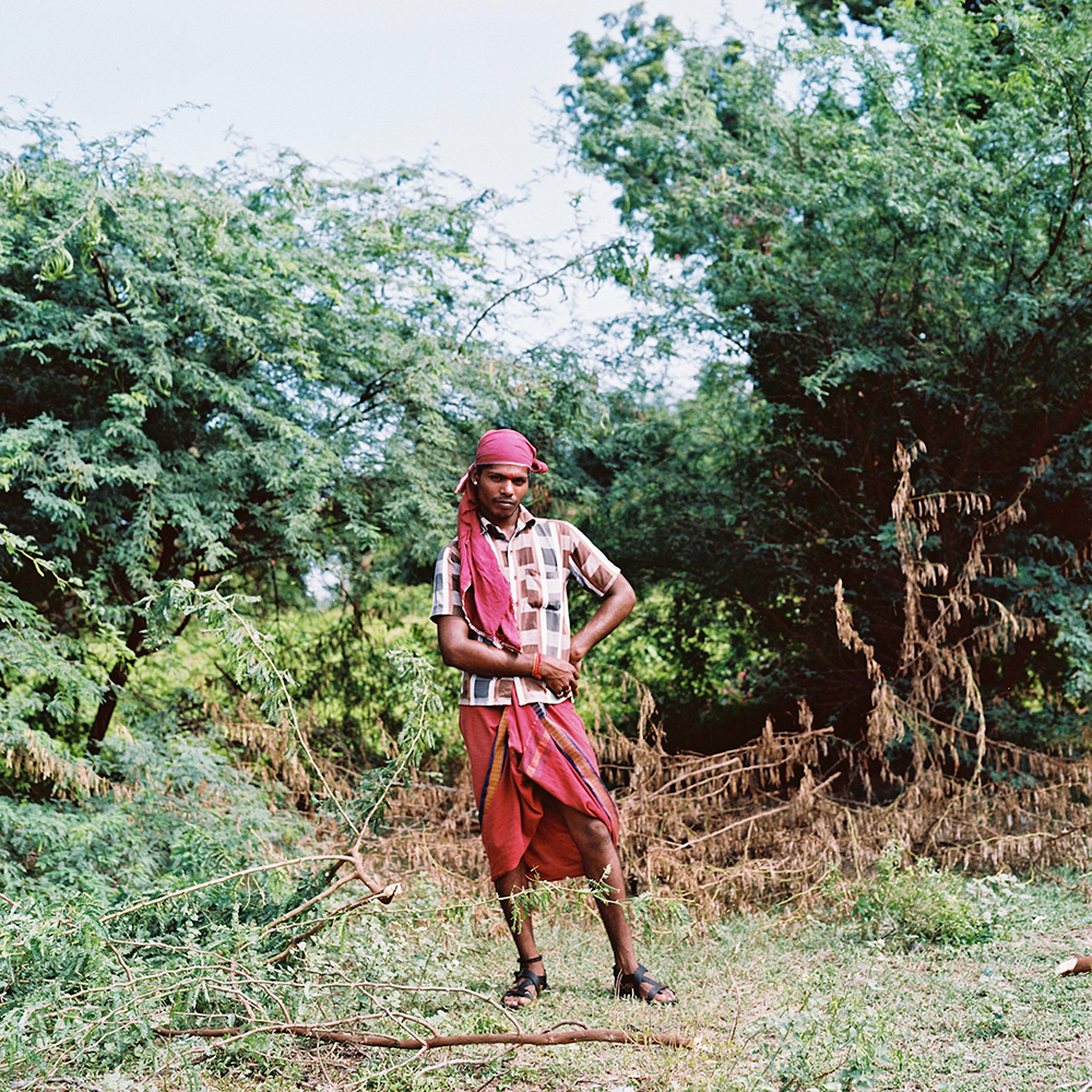   Chitra, a kothi priest from outside of Cuddalore, poses for a portrait while cutting down wood used for cooking. Many kothis choose to do this kind of work – which is traditionally done by women – as another way to express their female identity. No