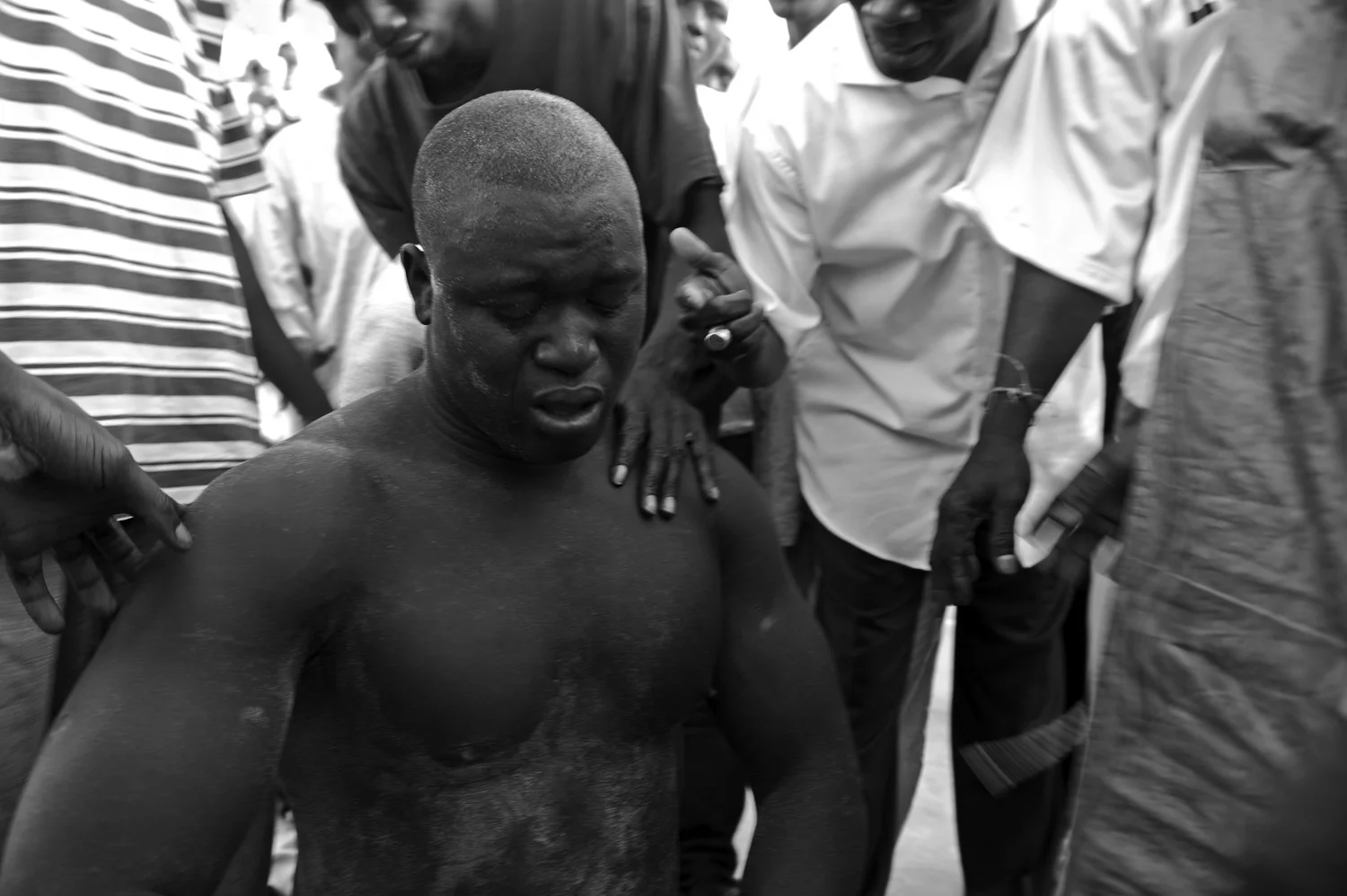 A wrestler is comforted after a loss. Along with the blow to the ego, each loss lessens the wrestlers chances of graduating to more lucrative matches.