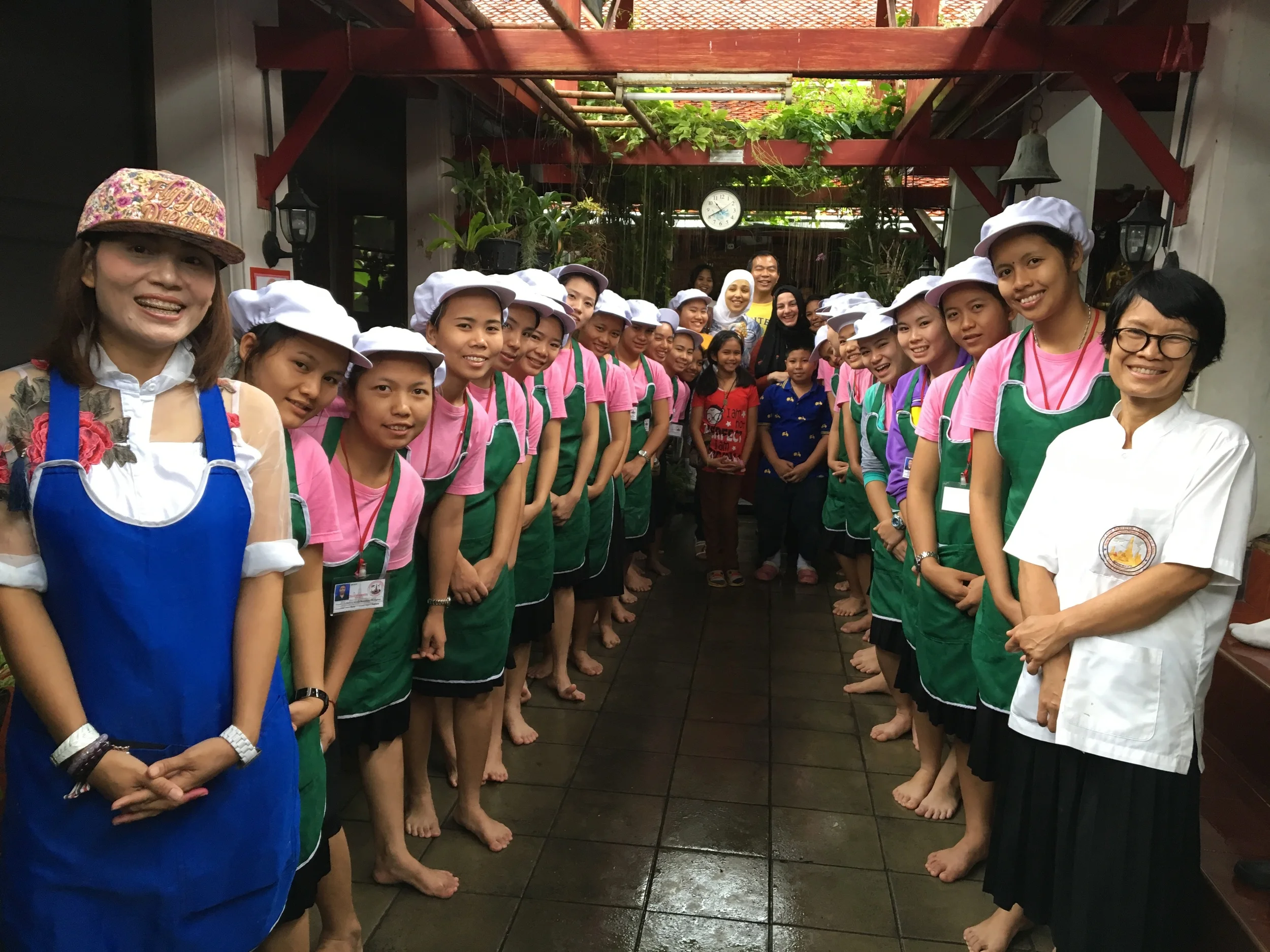 Sara, Ahsen, our Thai hosts and two rows of Thai girl students who greeted us at the Wat Arun Temple.