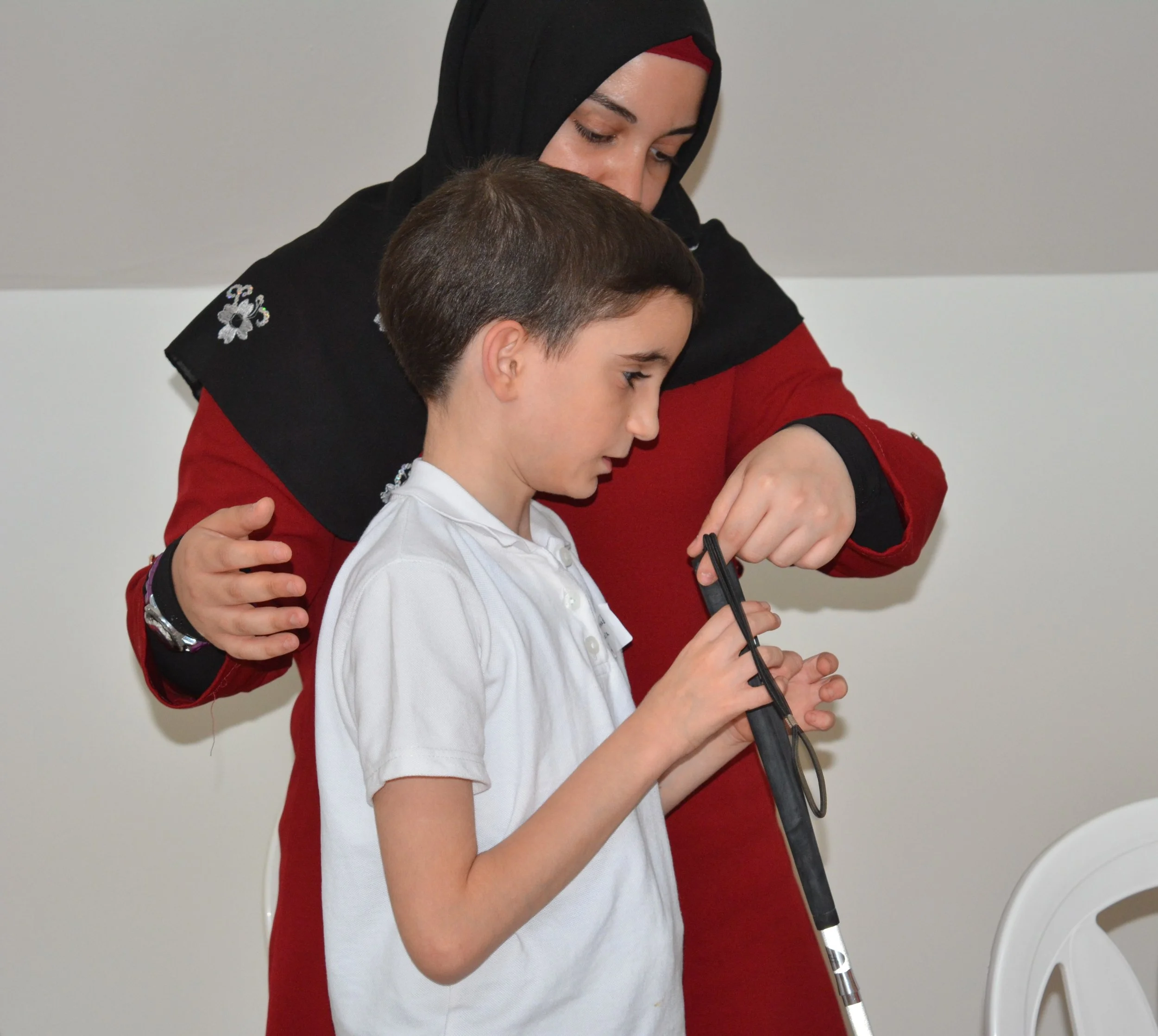 In the picture: a child learns how to hold a white cane.