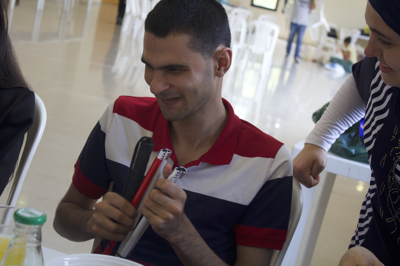In the picture: a Life Skill Program participant feels the tip of a white cane.