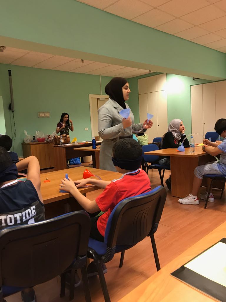 In the picture: Dr. Mona Minkara stands in front of a classroom full of students and teaches a science class.