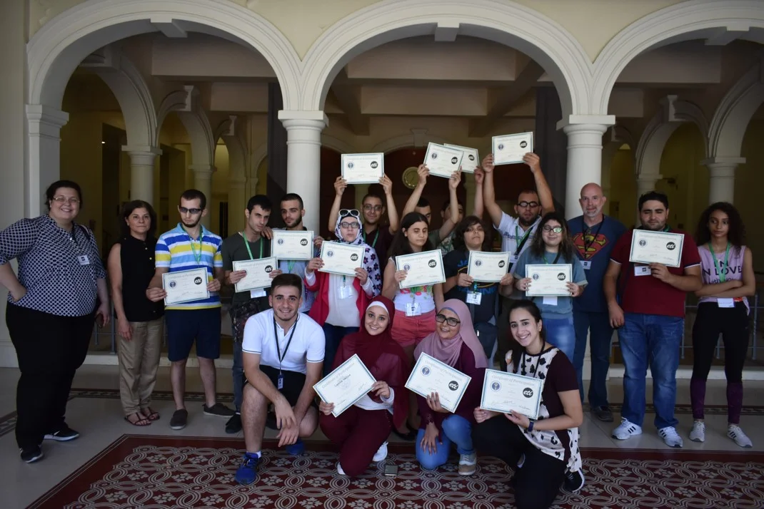 Visually impaired participants from group green (ages 18 and above) showing their certificates of participation, with Anna Barbosa, Edith Bitar from US Embassy, and volunteers