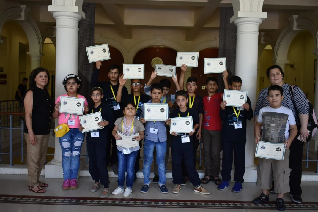 Visually impaired participants from group yellow (ages 11 to 14) showing their certificates of participation, with Anna Barbosa, Edith Bitar from US Embassy, and volunteers