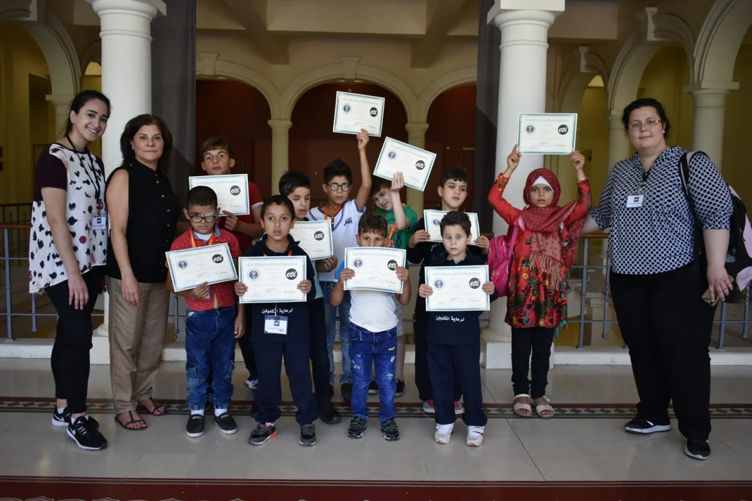 Visually impaired participants from group orange (ages 6 to 10) showing their certificates of participation, with Anna Barbosa, Edith Bitar from US Embassy, and volunteers