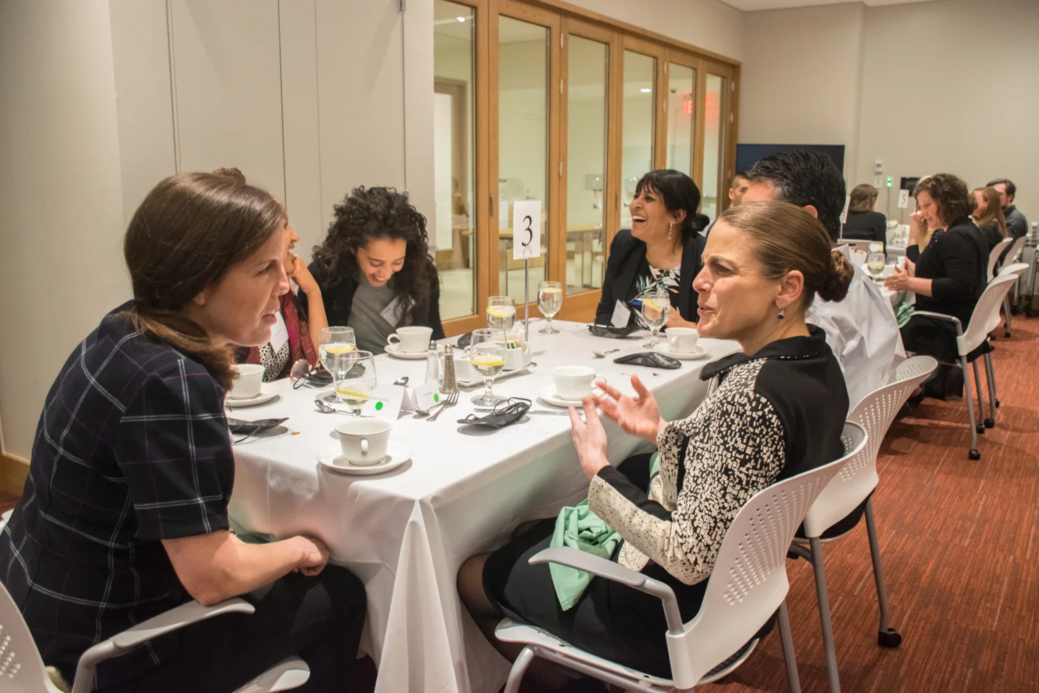 After removing their blindfolds, six participants sit around a rectangular table engaged in conversation