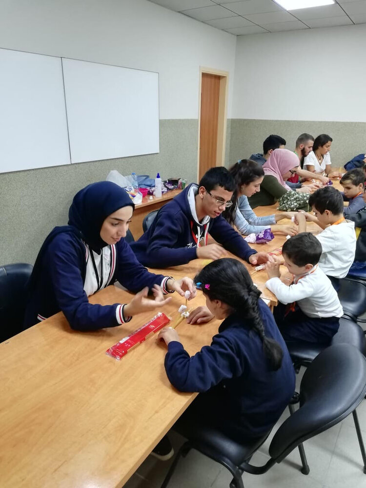 children talking to volunteers while doing experiments